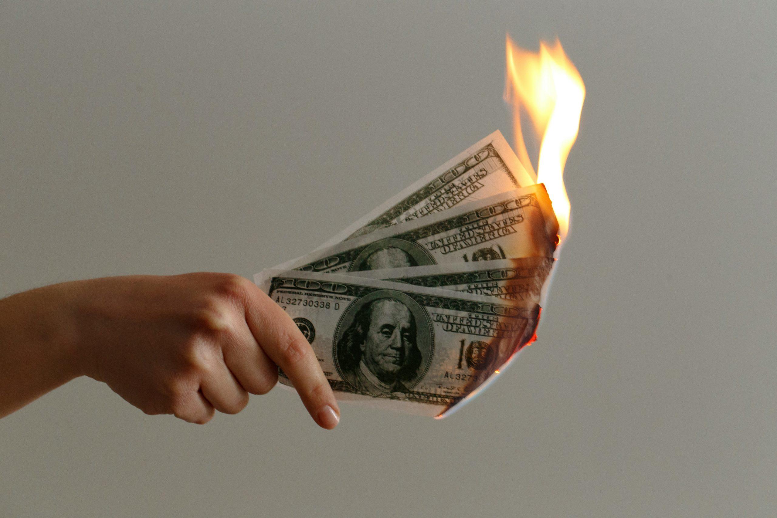 Hand holding out burning money