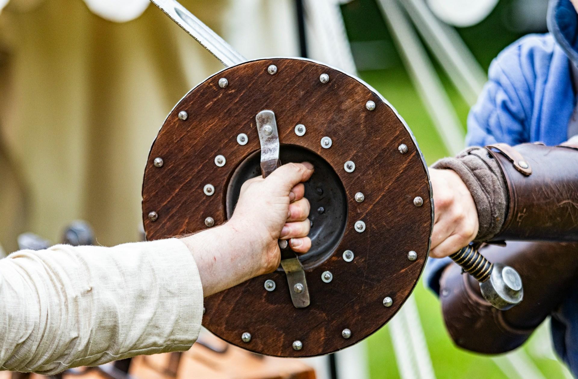 two people fighting with sword and spear