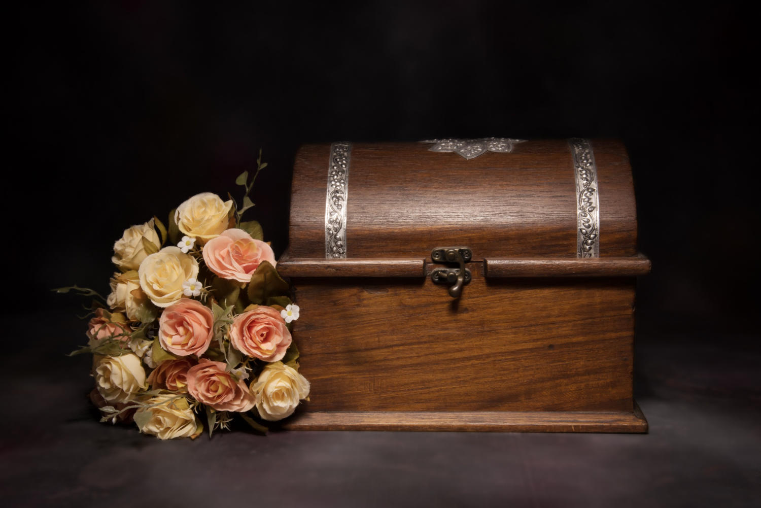 a locked casket with flowers beside