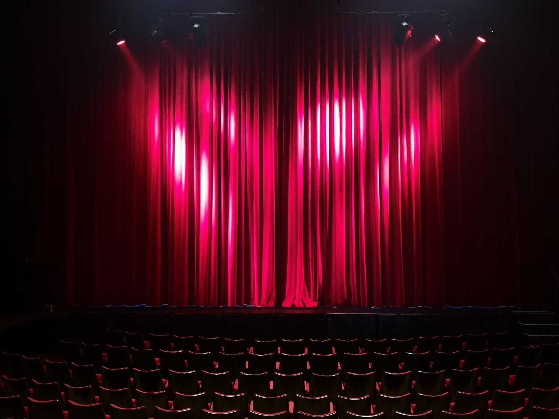 Red theatre curtains with stage lights shining on them