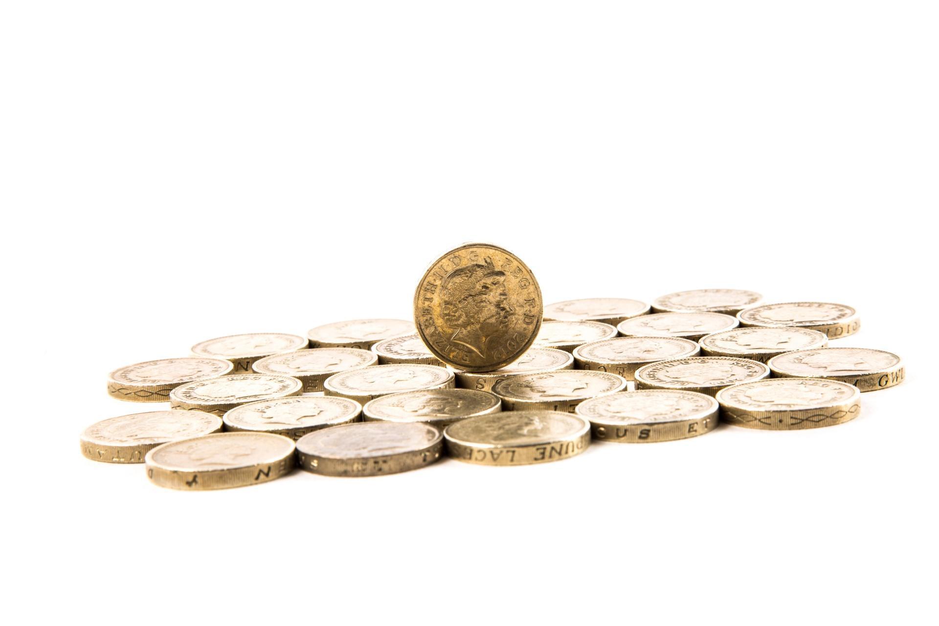 A collection of pound coins. The cost of an economics tutor should be considered.