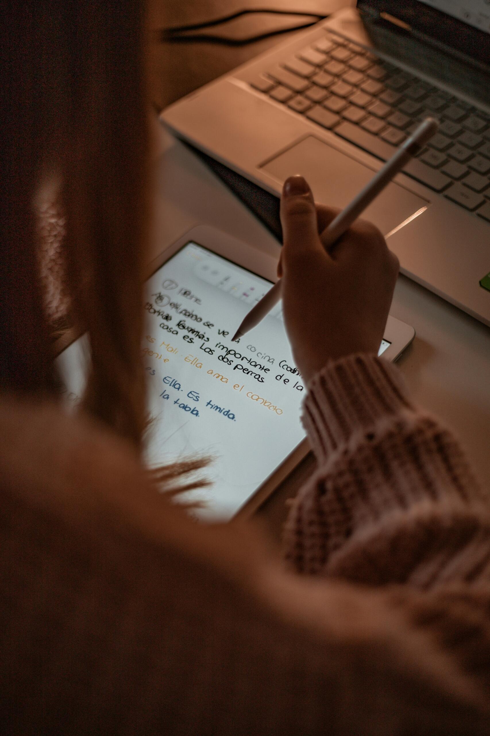 Persoană tânără care ține un caiet sau participă la o lecție online