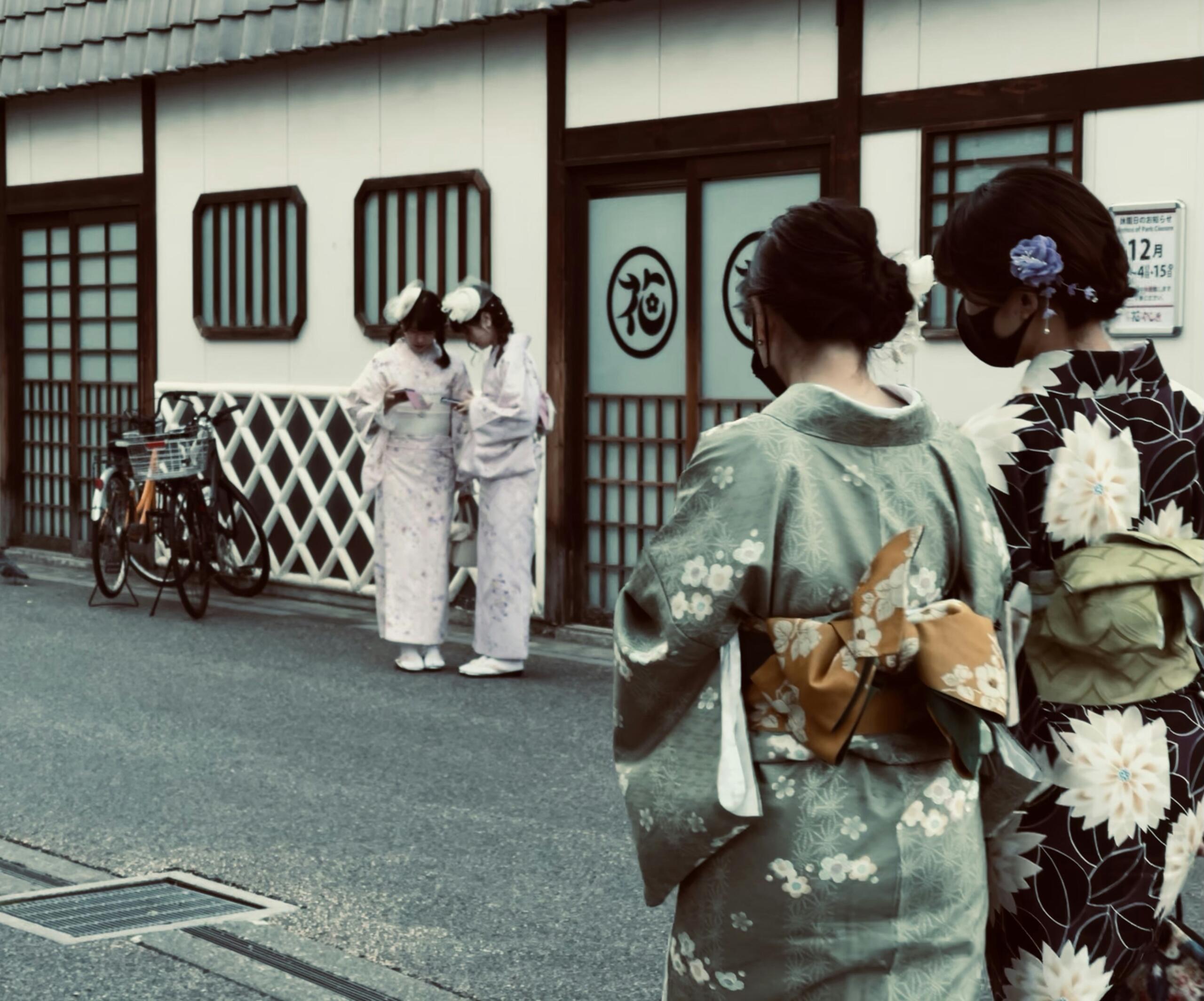 stradă tradițională din Kyoto, cu lampioane, case din lemn și siluetă de maiko sau geiko văzută discret din spate.