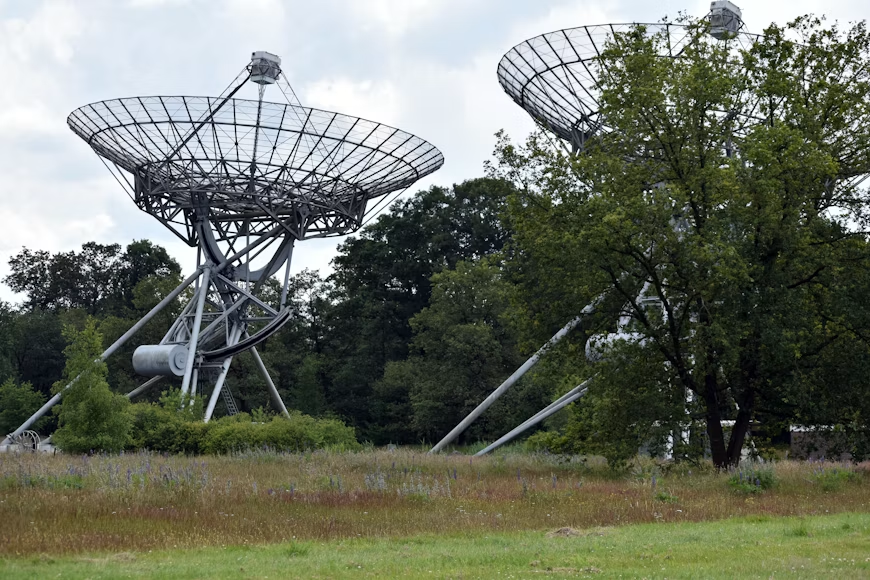 Par satelitskih antena postavljenih na bujnom zelenom polju.