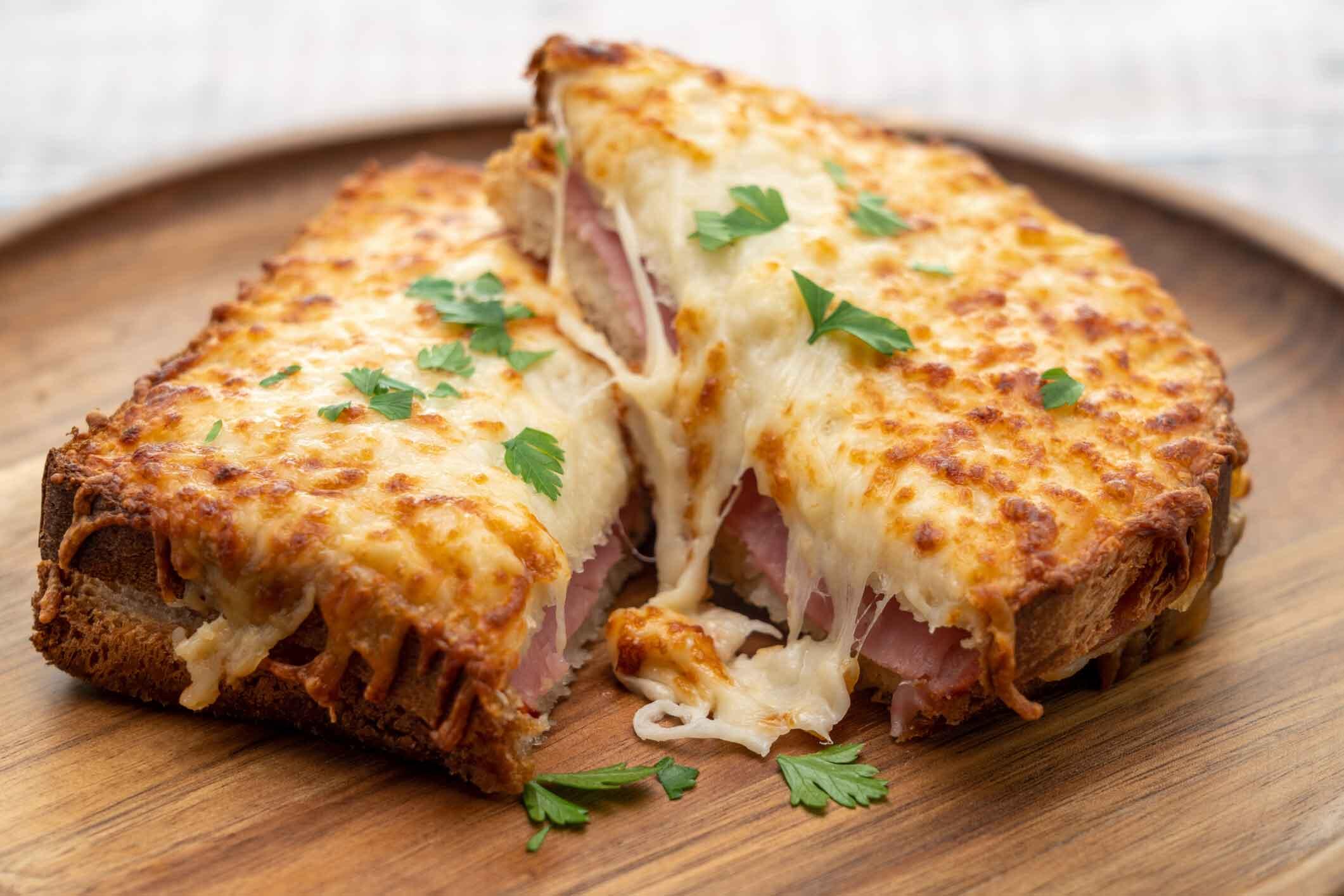 En klassisk Croque Monsieur på en assiett gjord av trä.