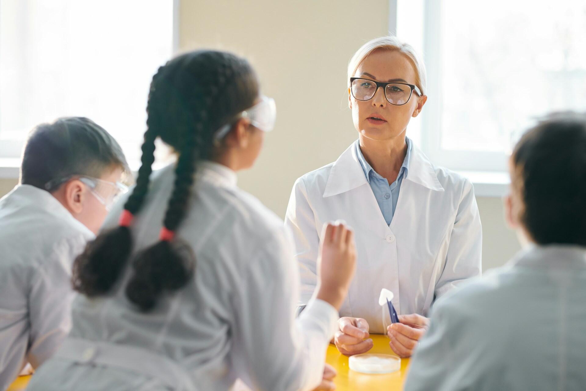 Barn med sin lärare på kemilektion