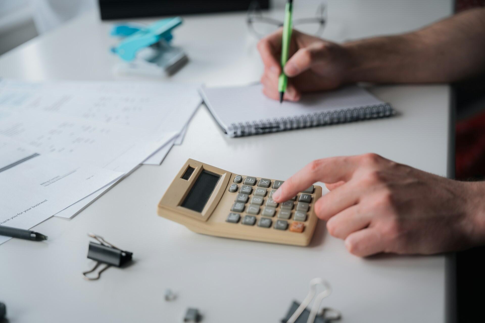Person som räknar matematik på en miniräknare.