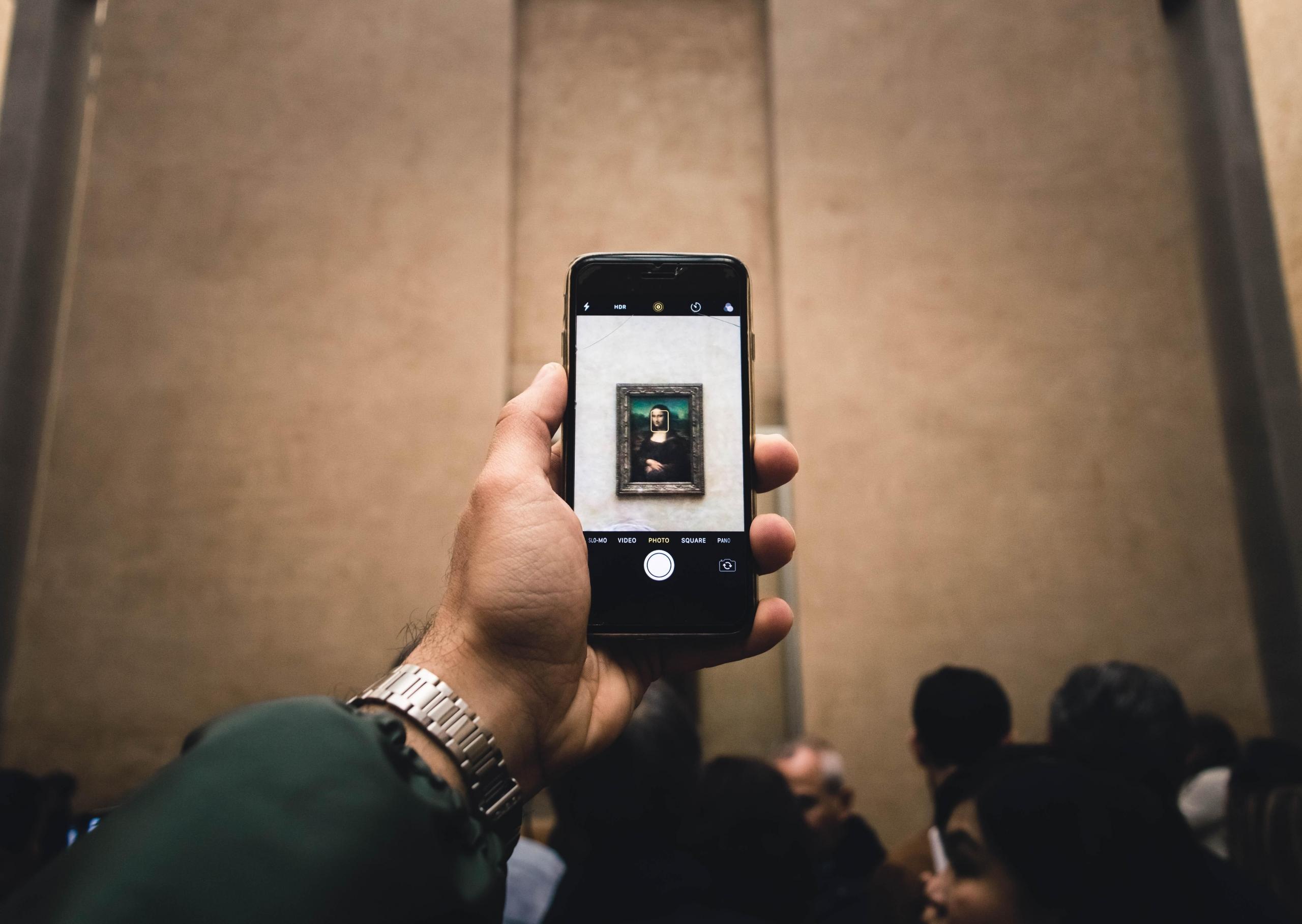 Man besöker Louvren och fotograferar Mona-Lisa