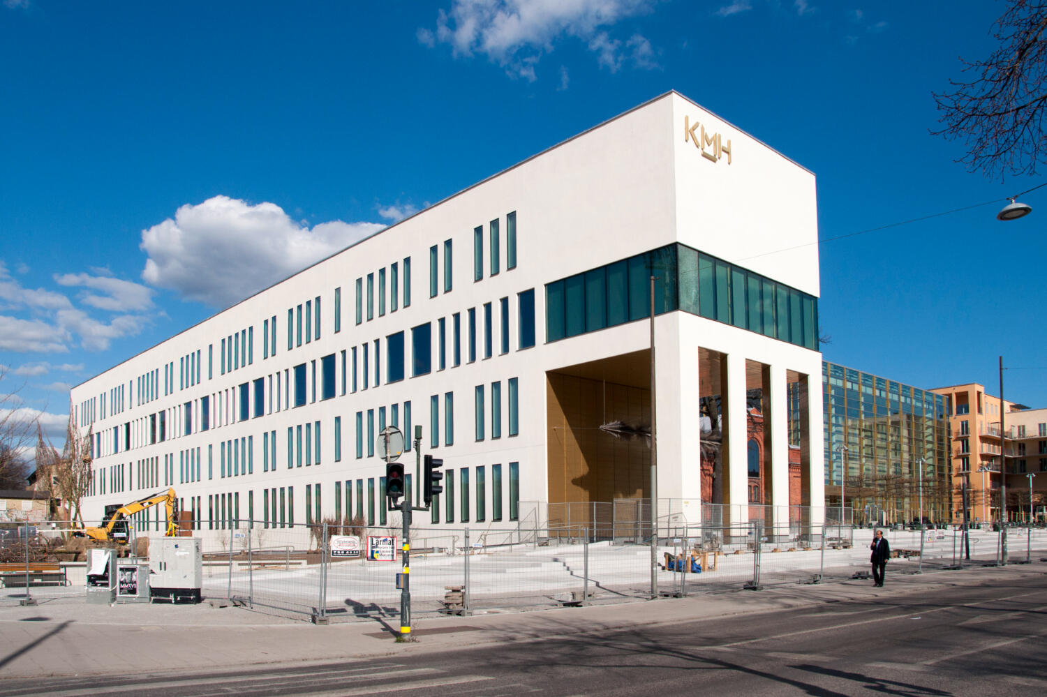 Kungliga musikhögskolans huvudbyggnad i Stockholm. En stor, vit, modern byggnad med stora fönster som vetter åt alla håll.