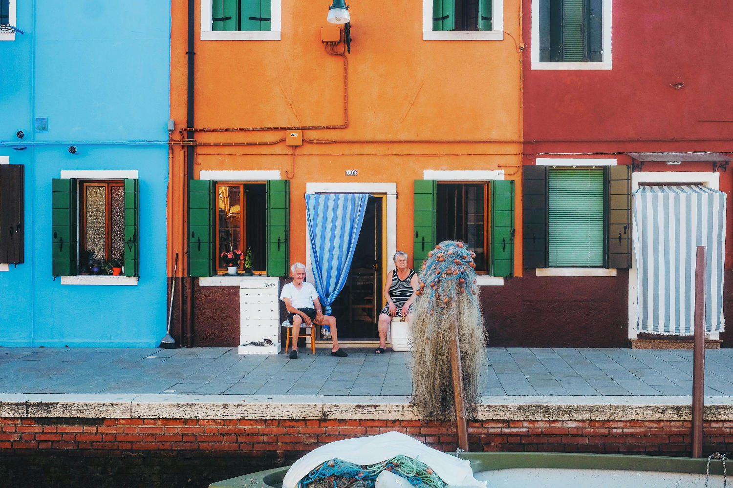 Två kvinnor som sitter utanför sina hem i Italien.