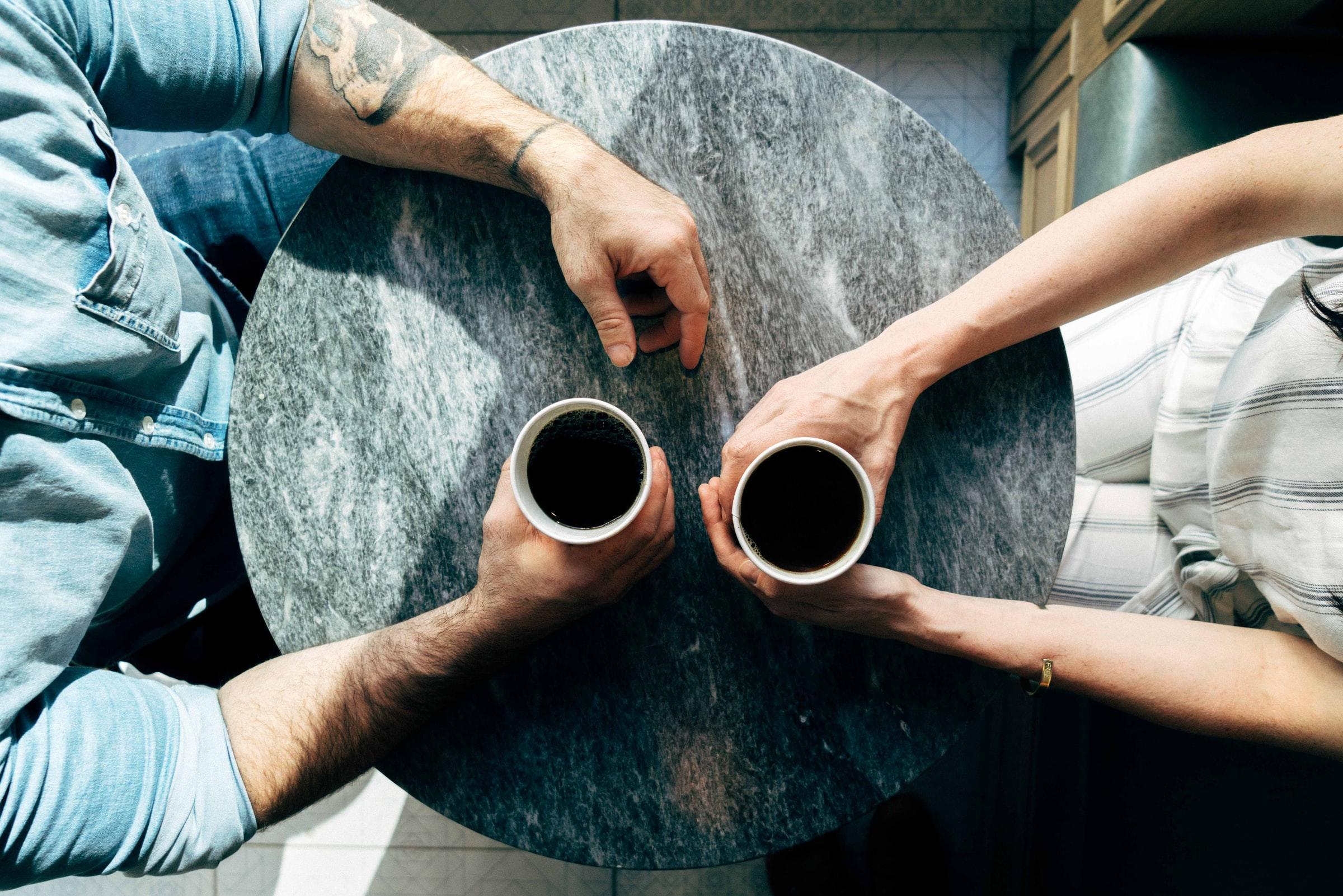 två personer dricker kaffe under livscoaching-möte