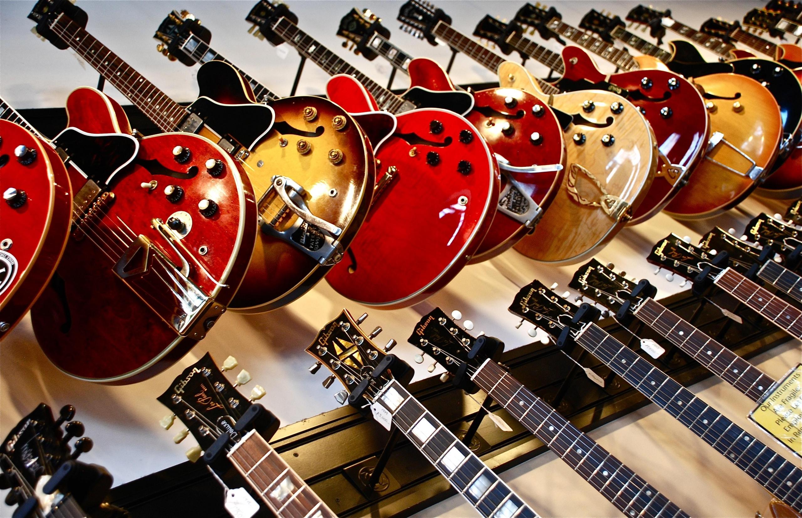 ett gäng les Paul-gitarrer hänger på väggen i en musikaffär