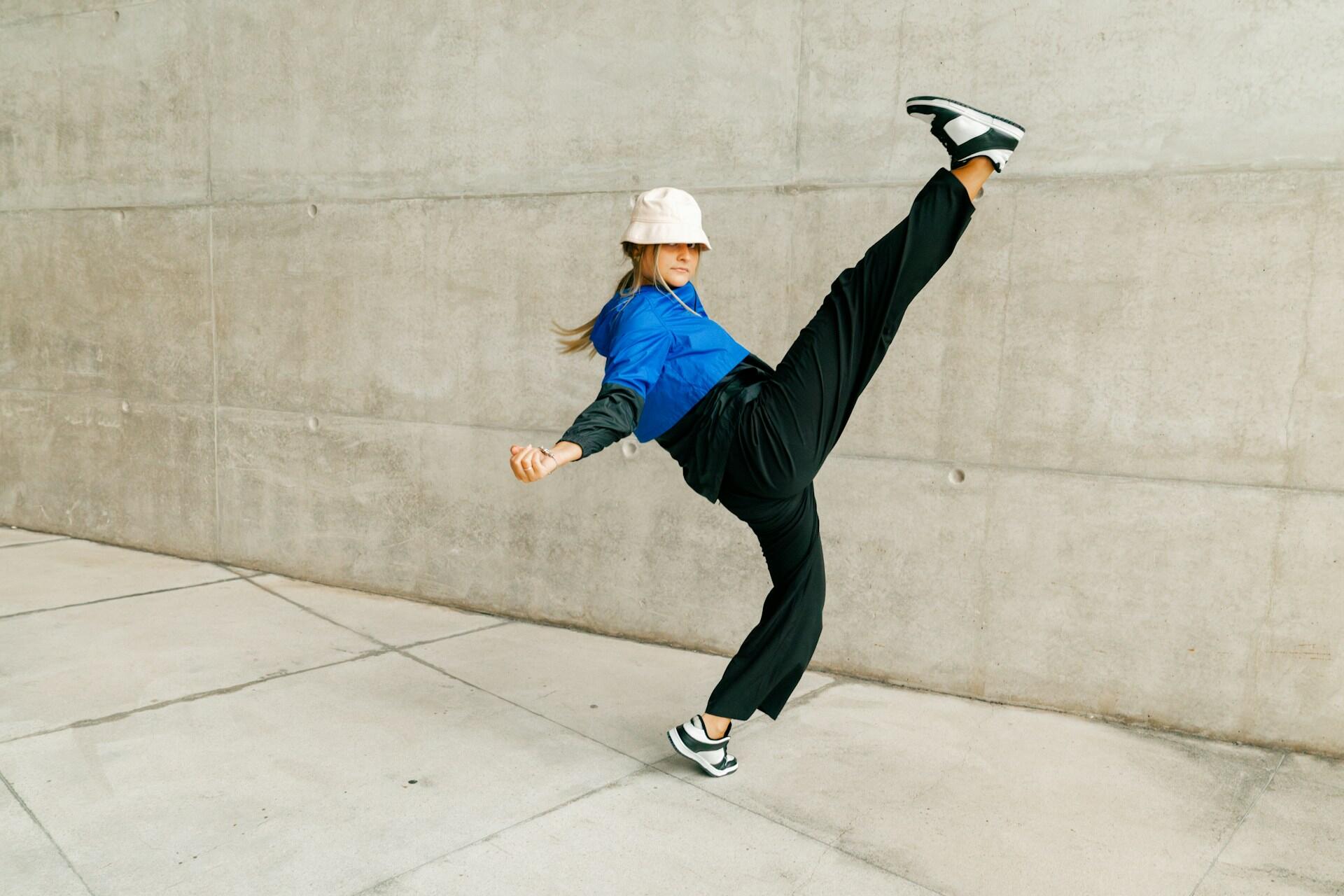 Kvinna som dansar breakdance utomhus.