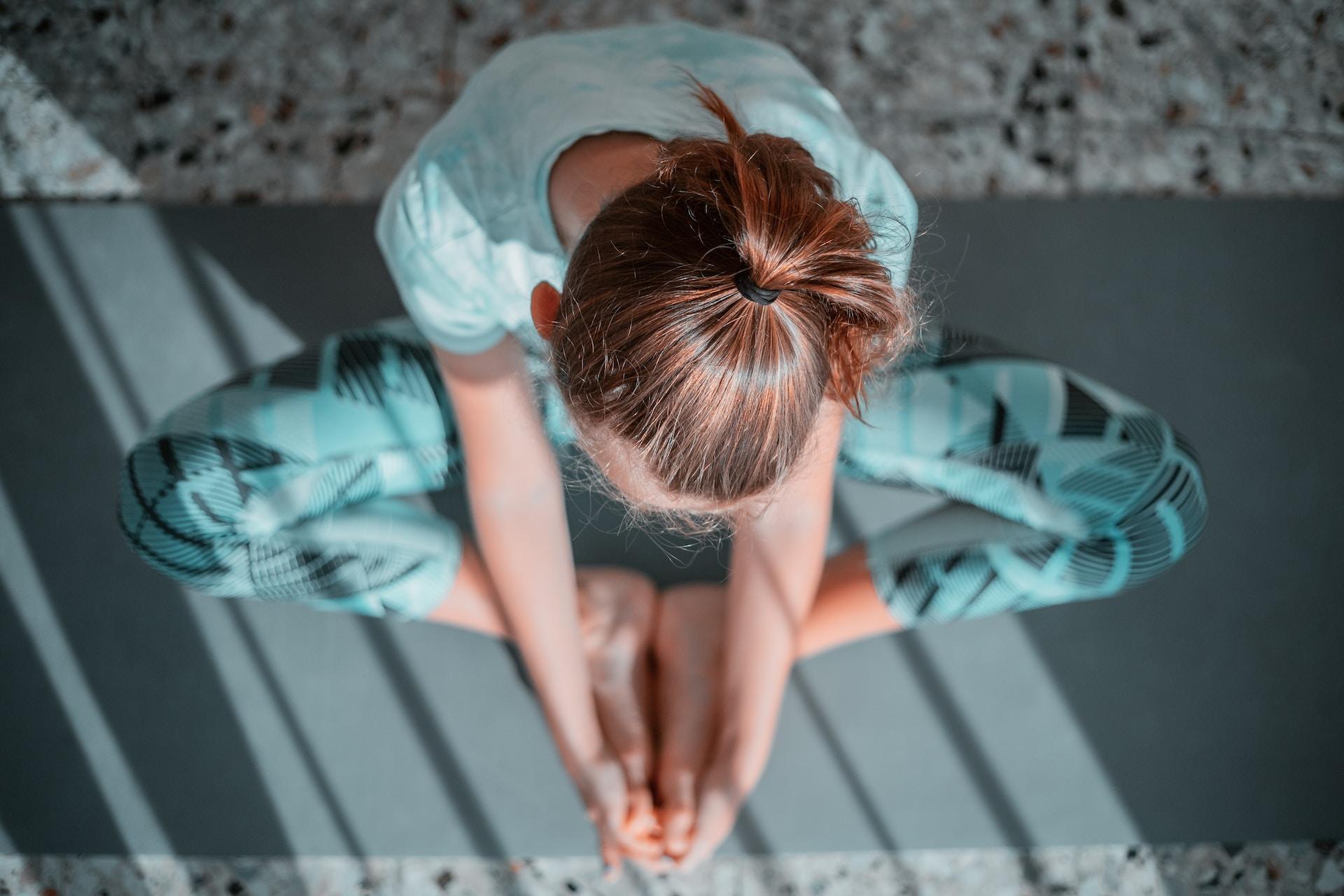 Kvinna som utför yoga på en yogamatta.