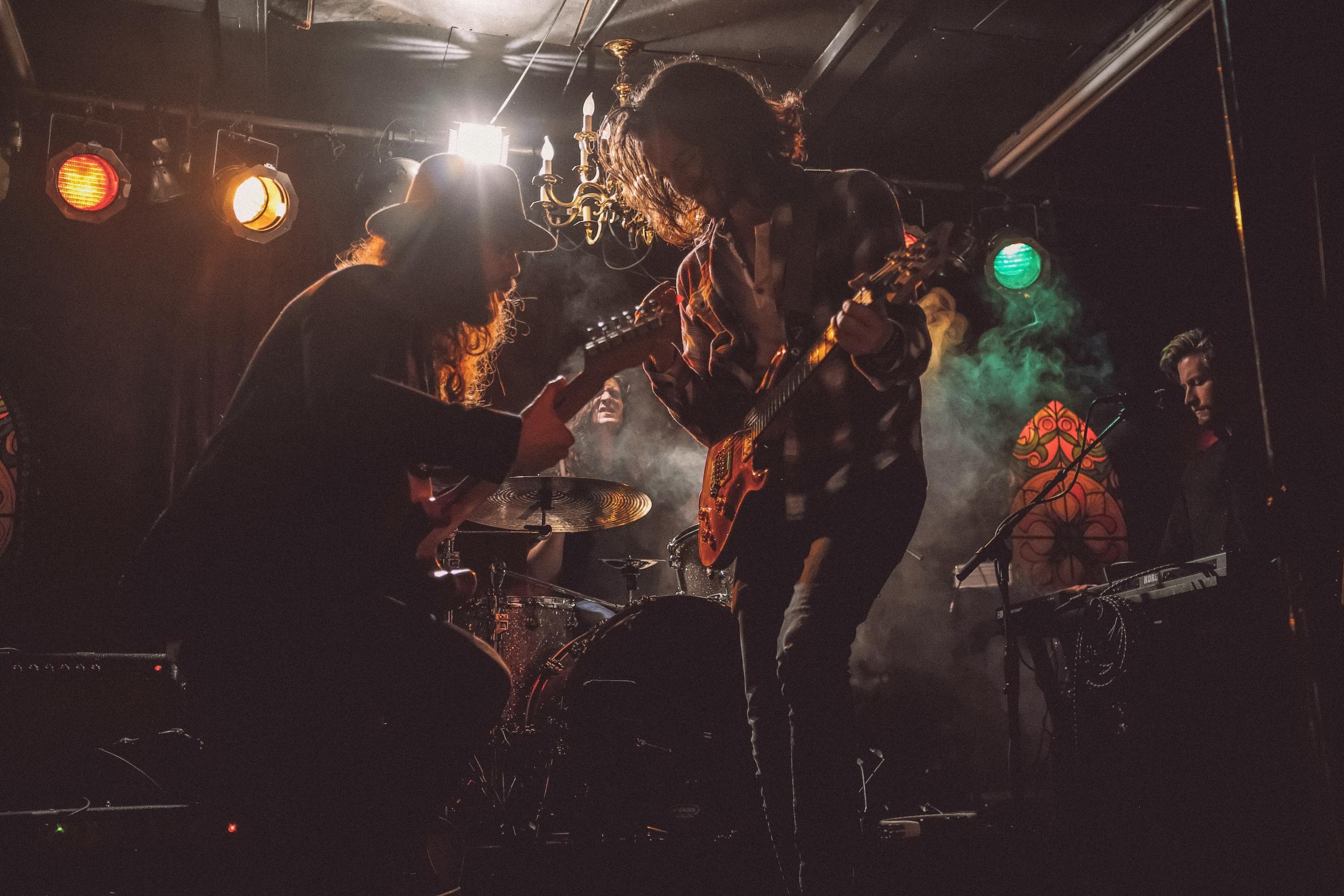 två män sjunger och spelar gitarr på rockscen