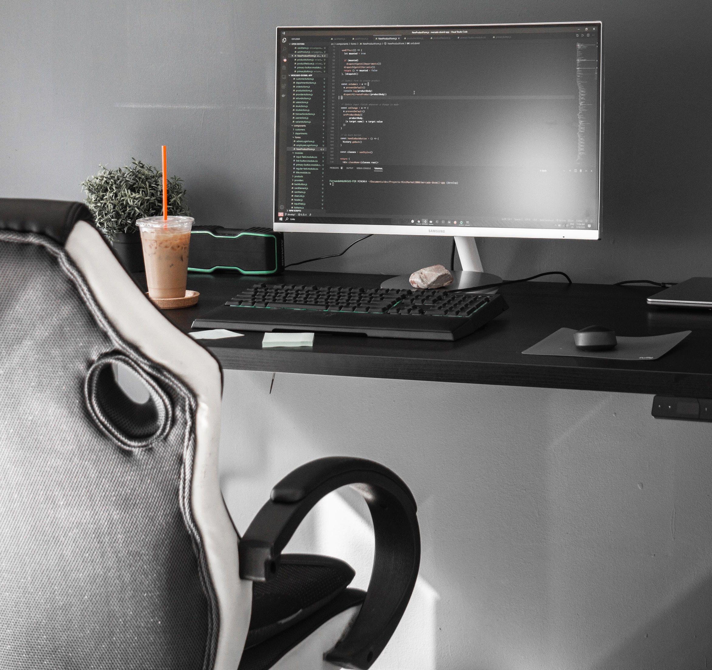 Ett skrivbord med en dataskärm på. Framför den står en ergonomisk stol.
