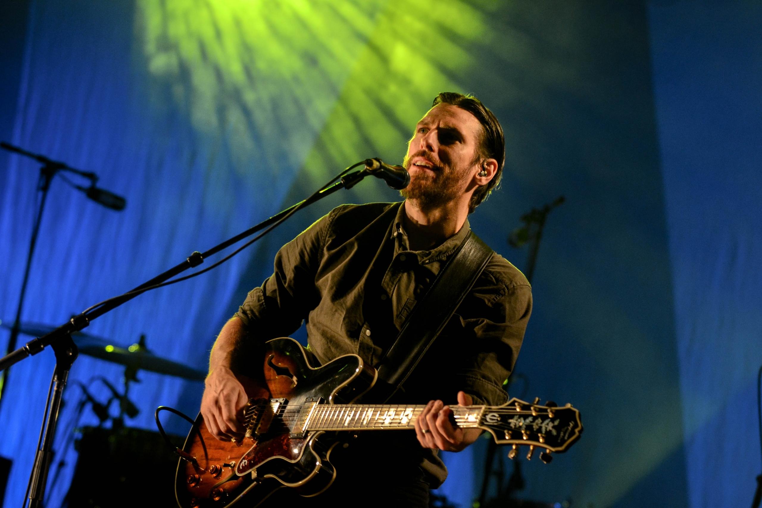 Man som spelar elgitarr och sjunger på scen