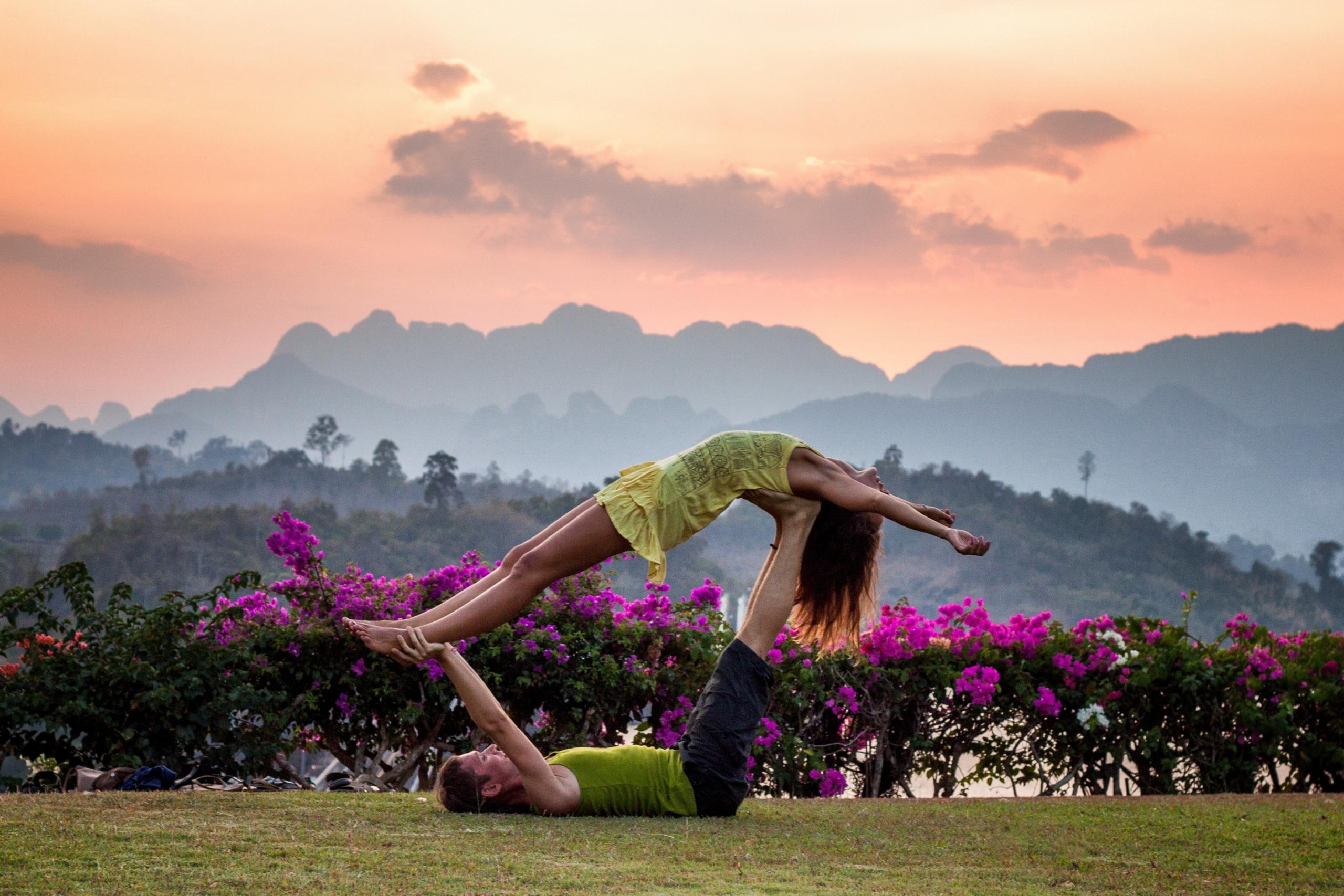 par gör yoga på gräsmatta