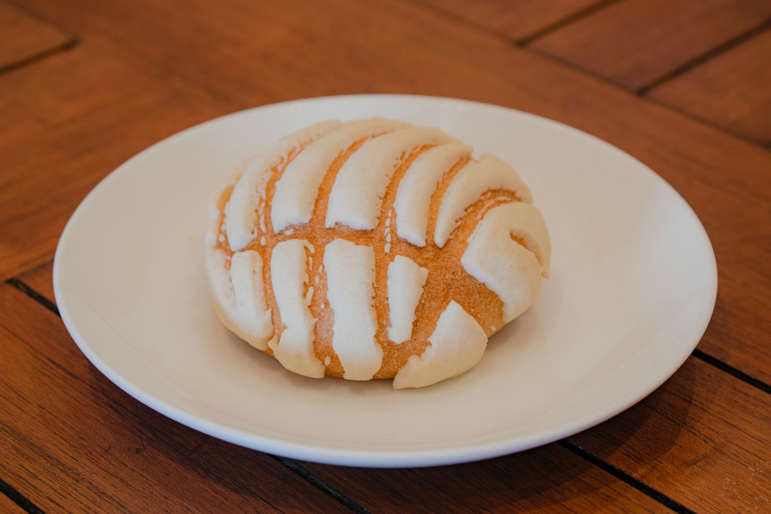 Pan dulce på en vit tallrik på ett träbord