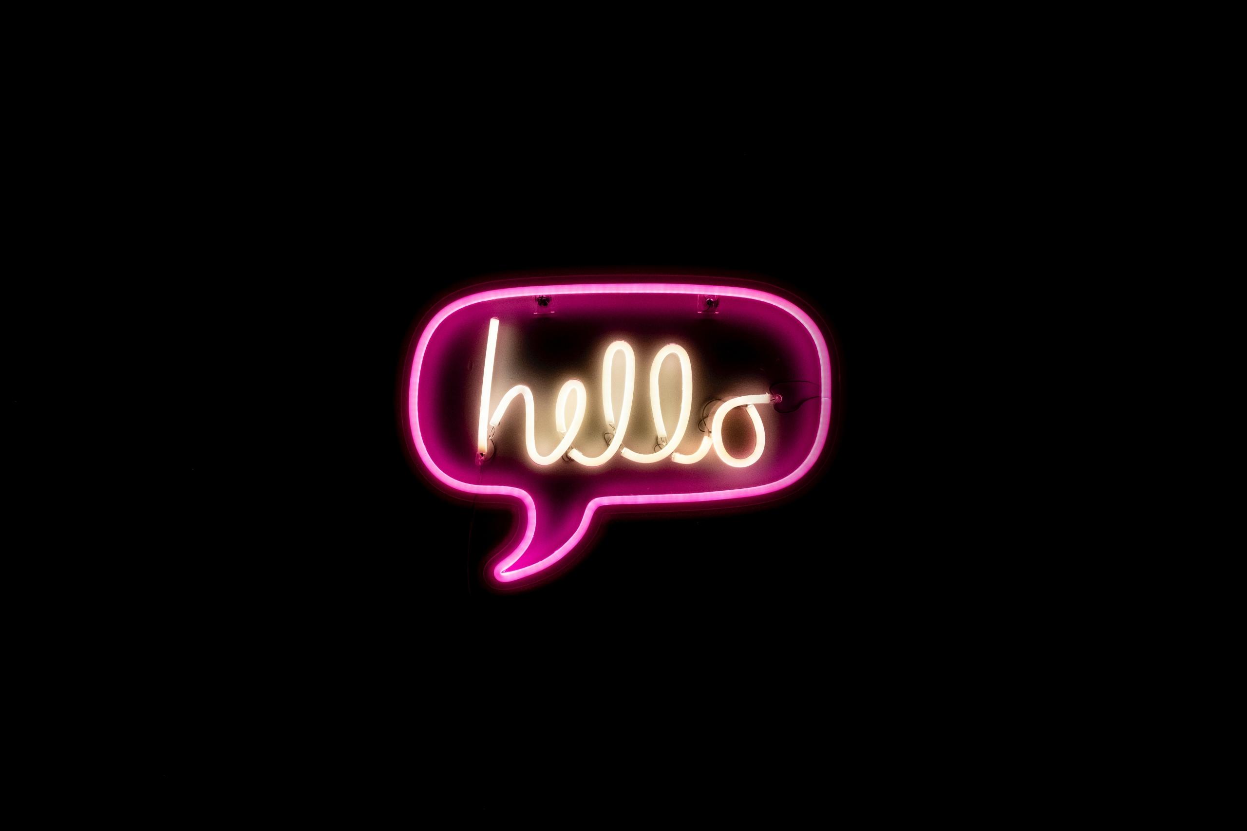 En neon-skylt med den engelska hälsningsfrasen hello.