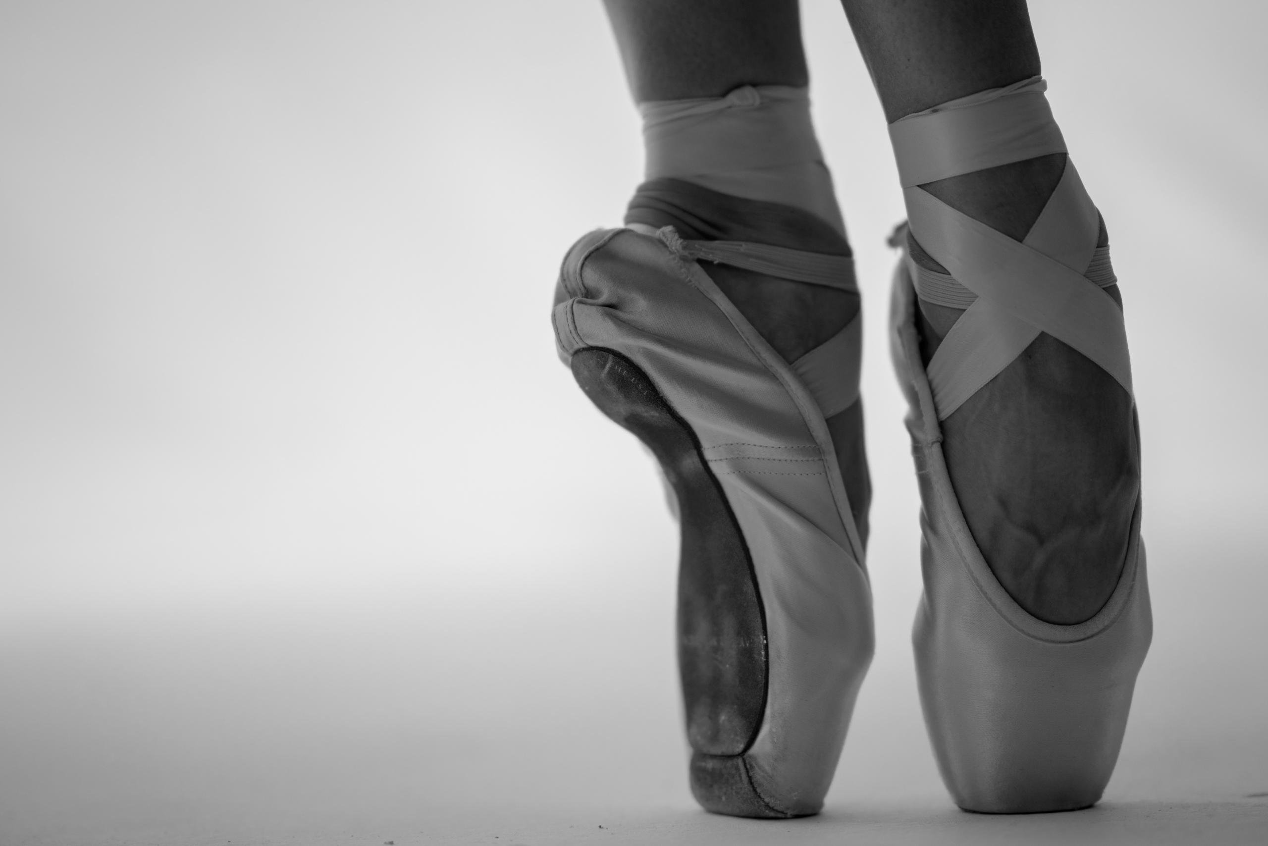 En ballerina som står på tårna i balettskor.