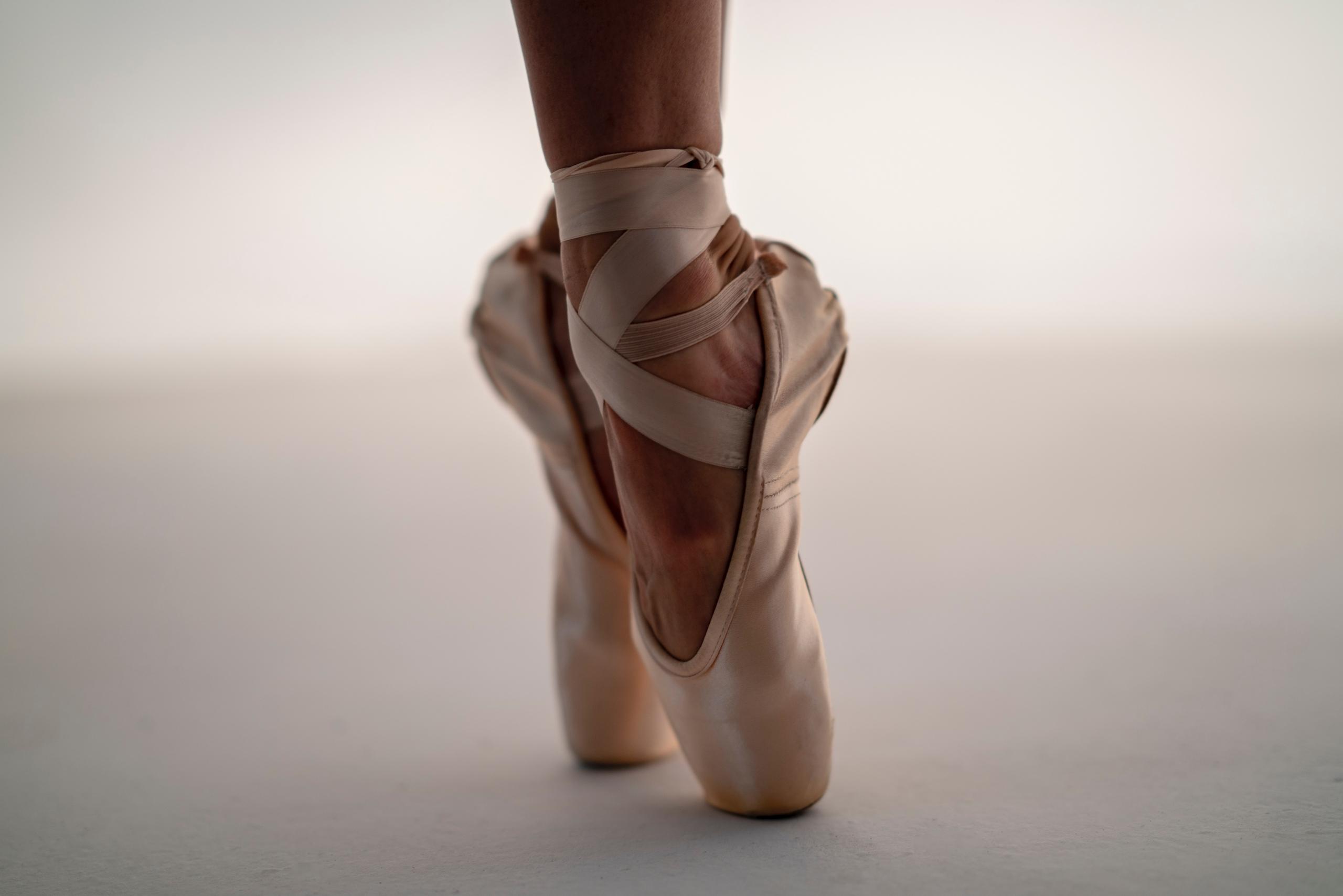 En ballerina som står tåspetsarna i en balettrörelse.