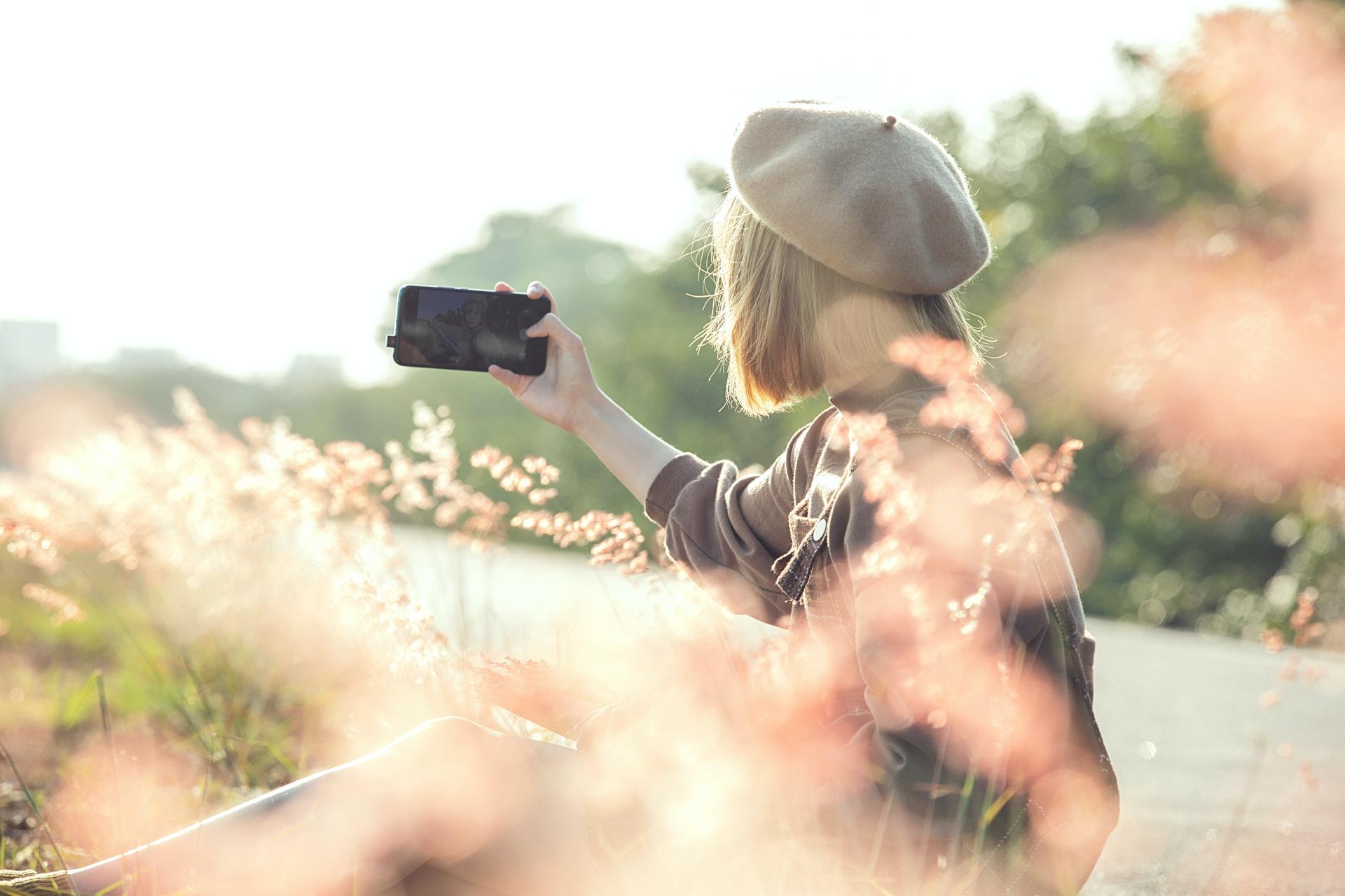 Kvinna som fotograferar sig själv utomhus