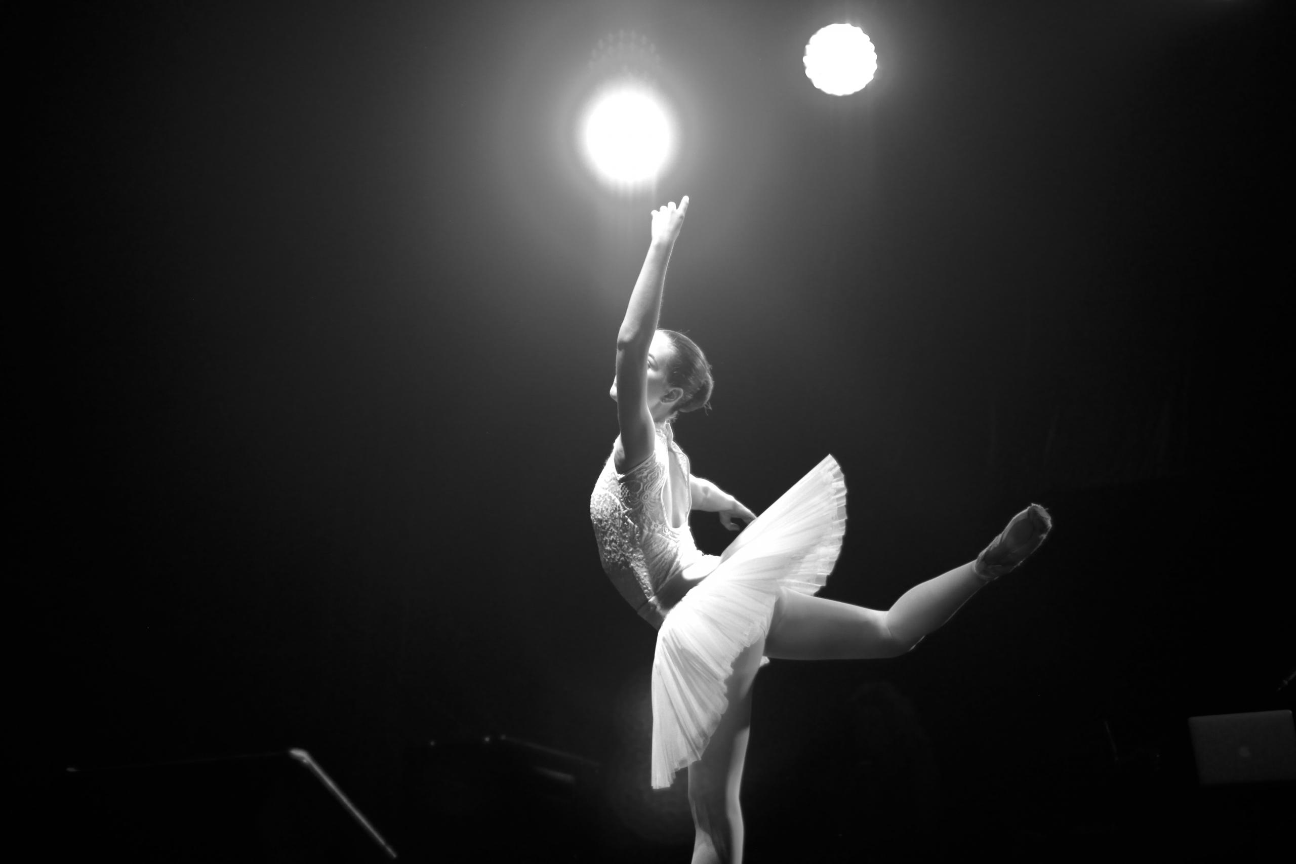 En ballerina dansar ett solo på en scen.