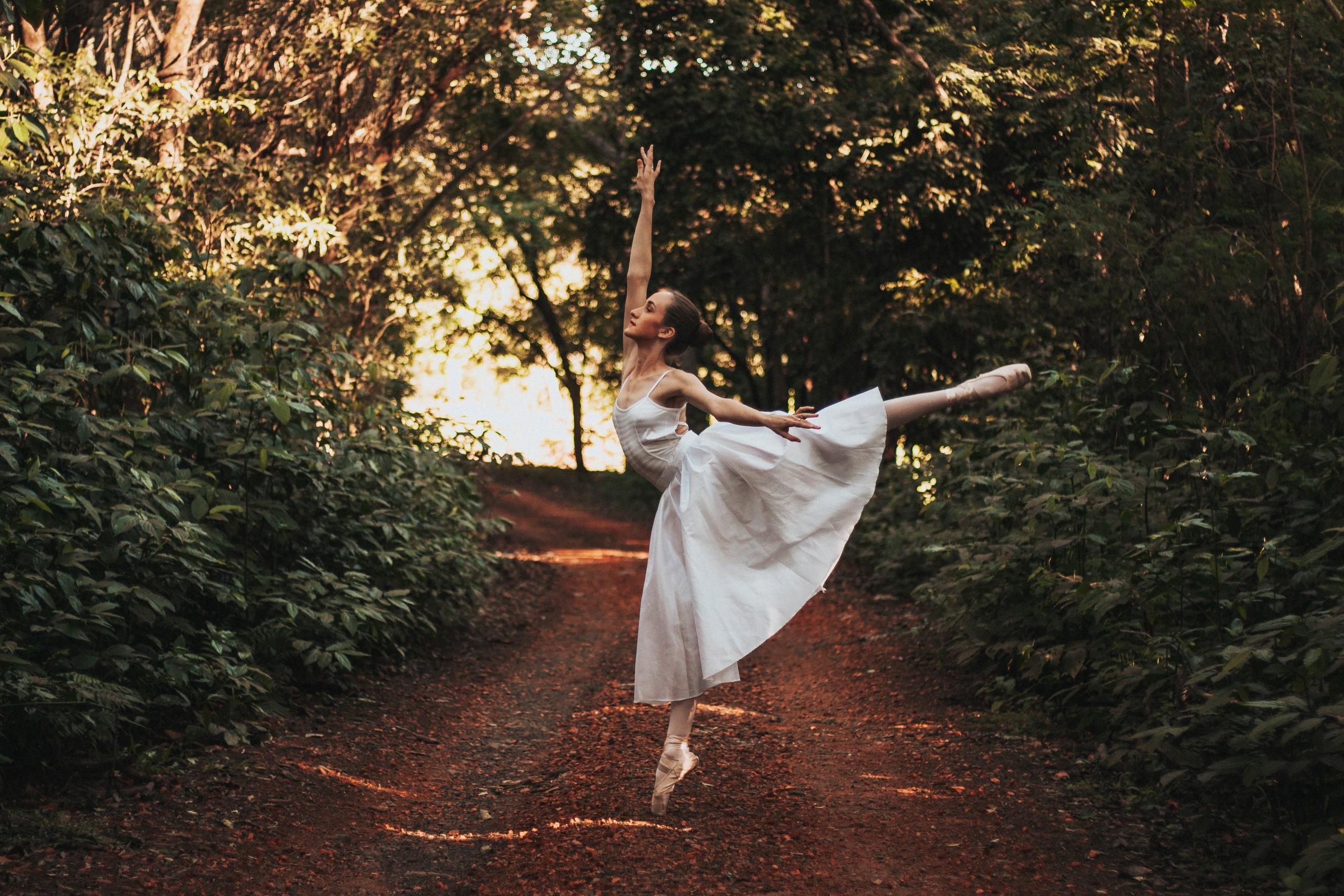 En ballerina som övar på att dansa till rysk musik i skogen.