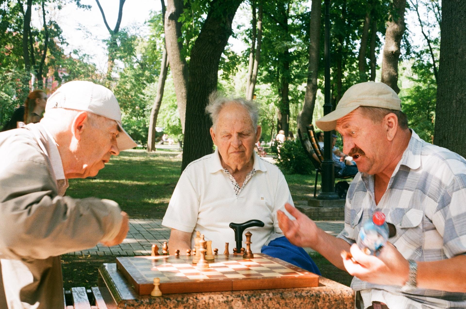 Tre gubbar som spelar schack