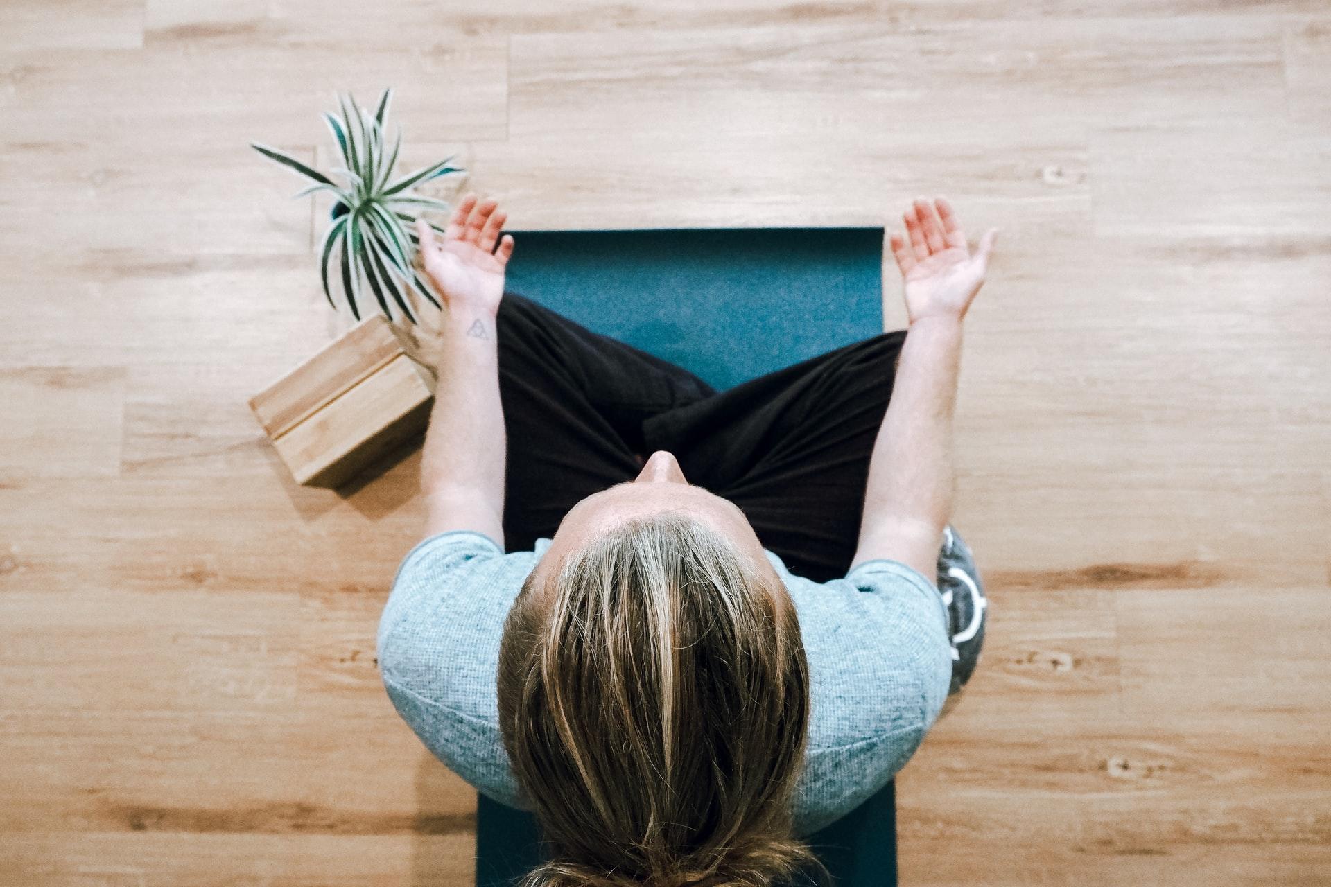 kvinna sitter i yogaposition ovanifrån