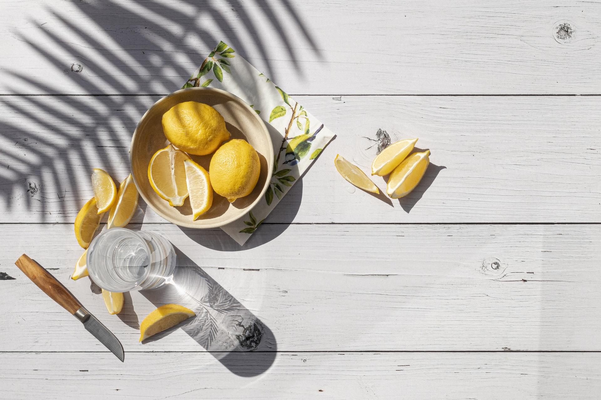 Citroner och vatten ovanfrån som någon gör iordning för att få en plattare mage