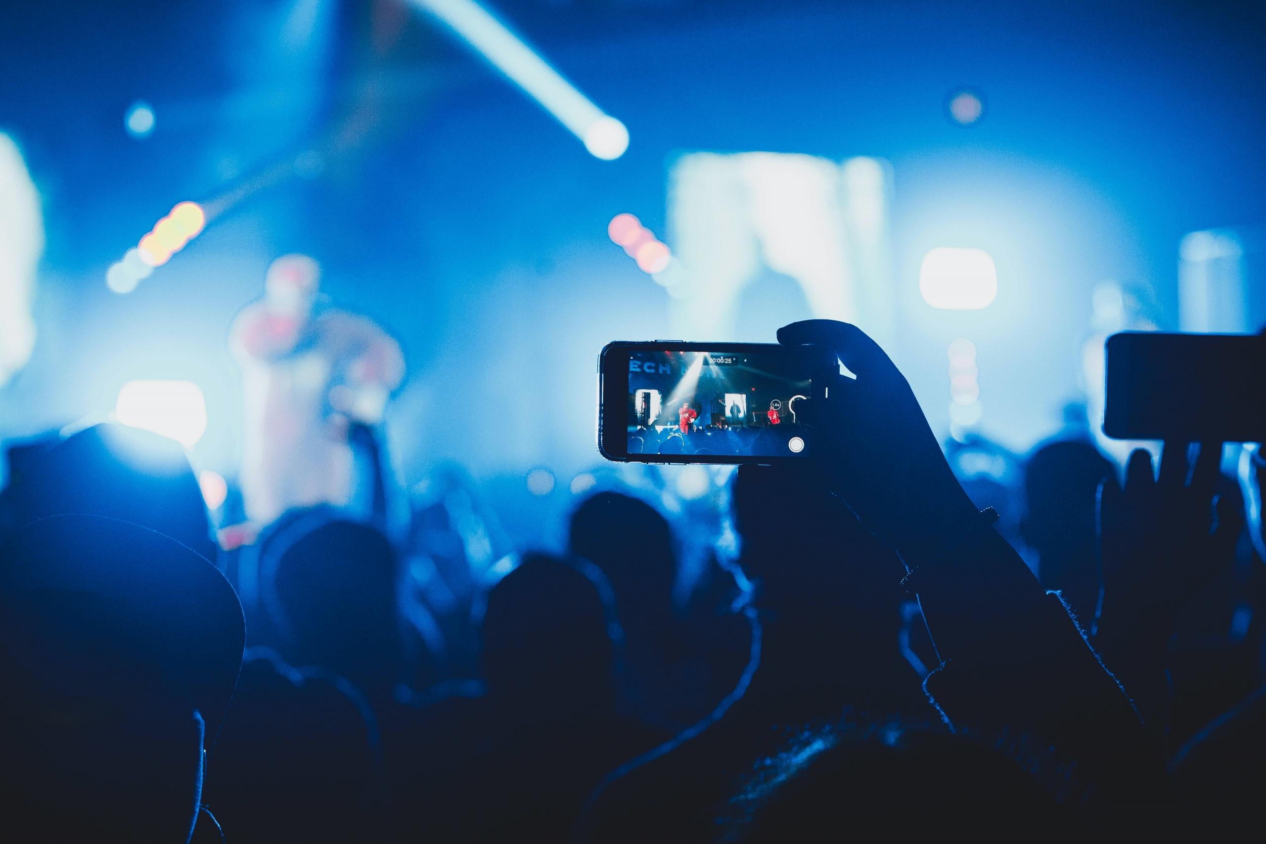 Mobiltelefon som fotograferar rapkonsert