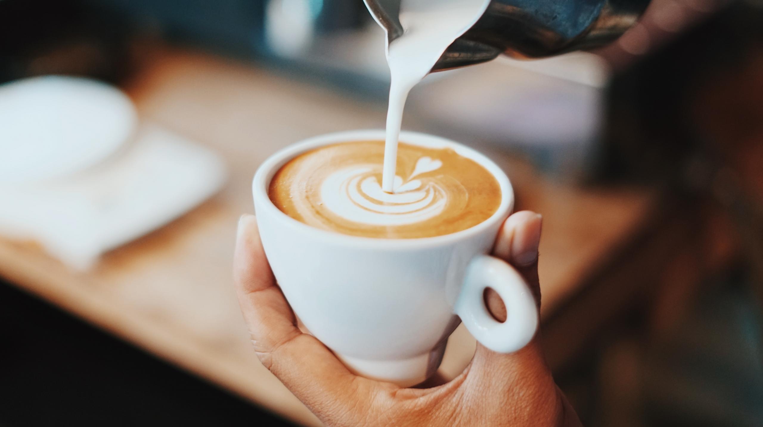 En full kaffekopp står på ett bord. Vilket genus har ordet kaffe på tyska?