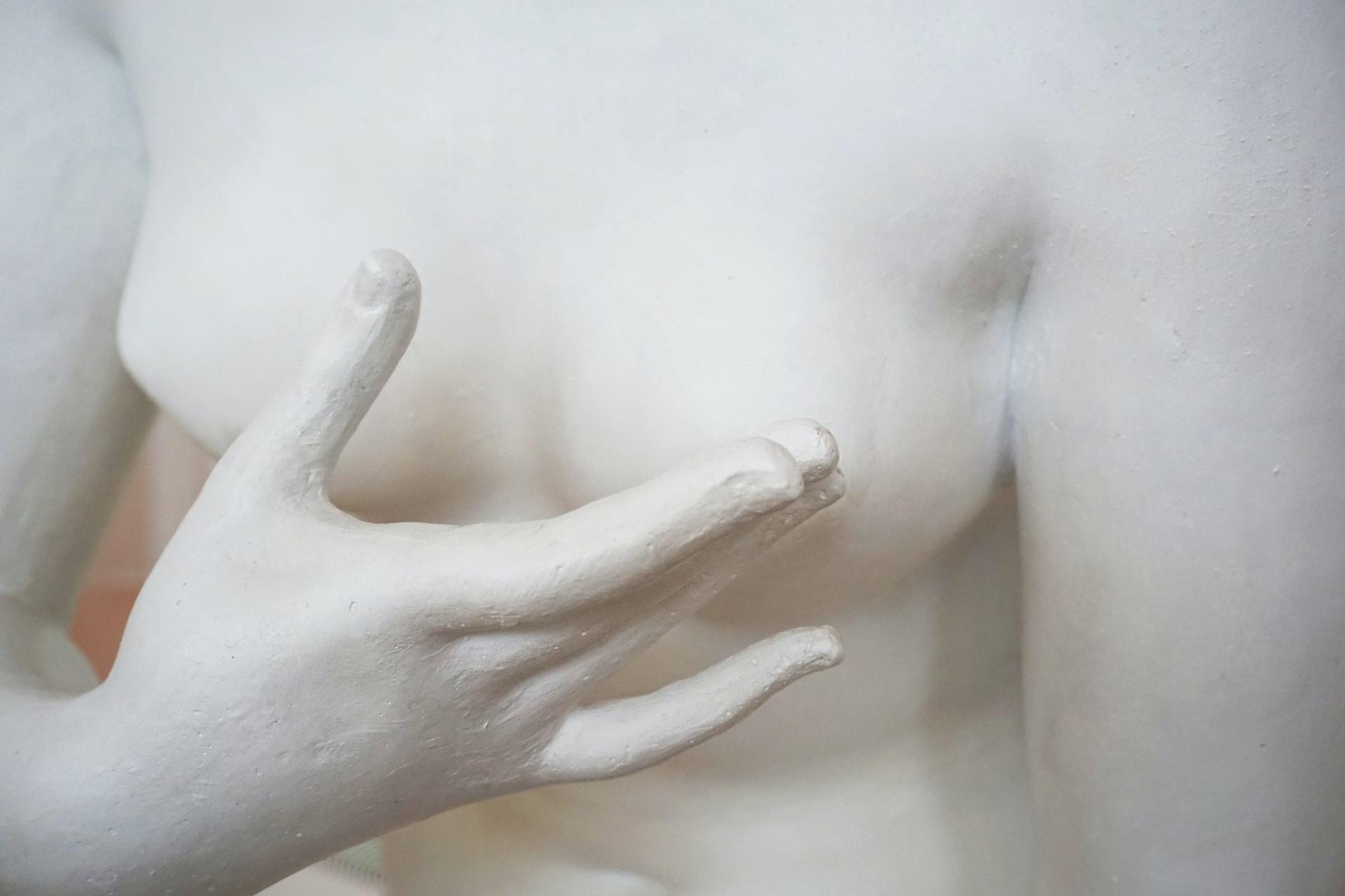 Närbild på hand på staty