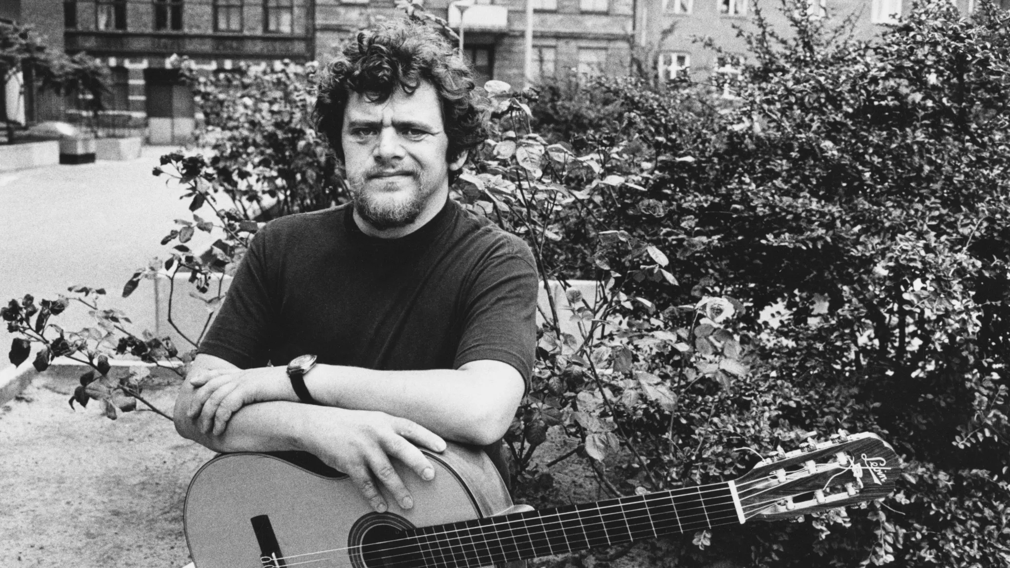 Fred Åkerström poserar med en gitarr