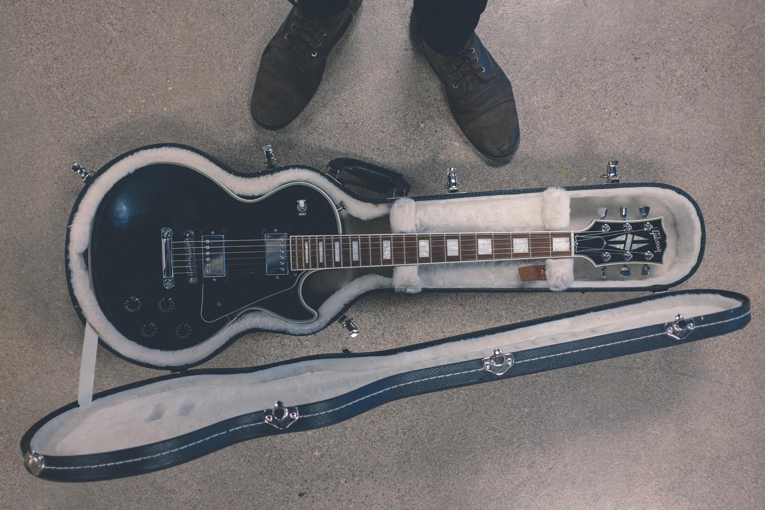 En vacker Gibson-gitarr ligger i sitt fodral.