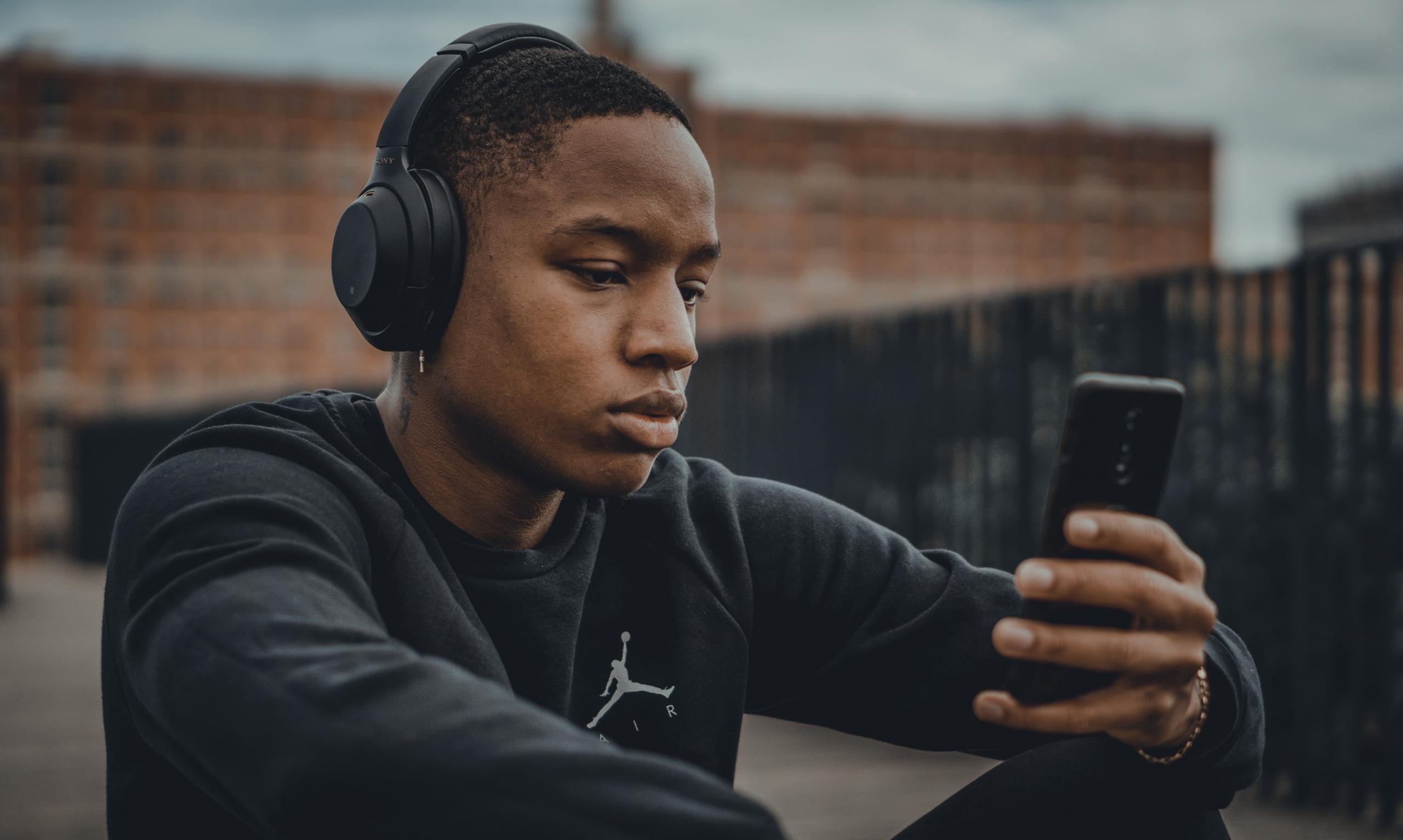 Kille lyssnar på musik på telefonen