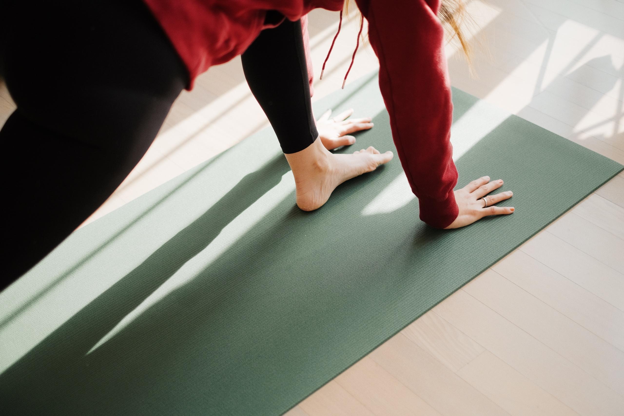 En elev drar nytta av sin yogamatta för att få bättre balans i rörelsen.