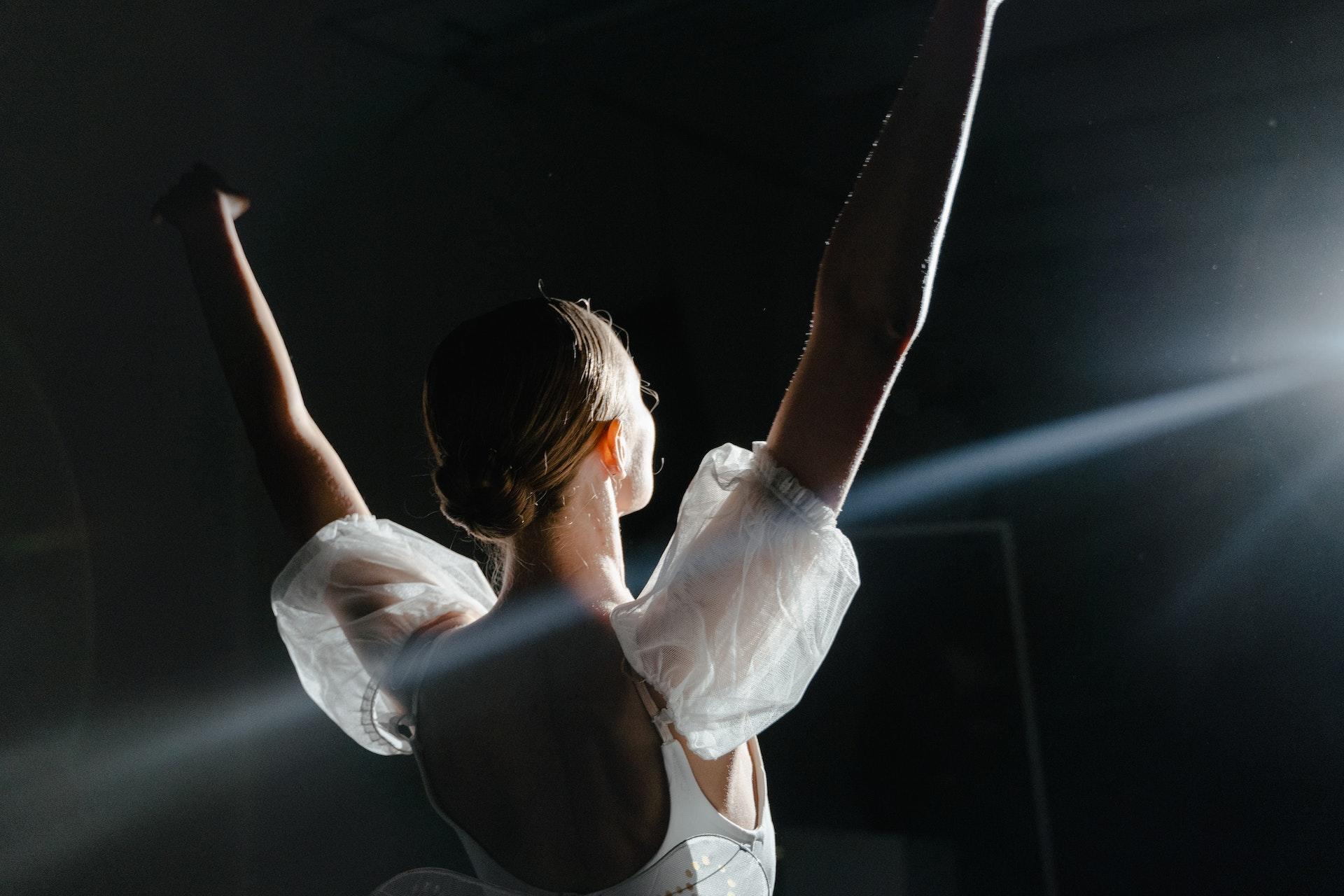 ballerina på scen mot svart bakgrund