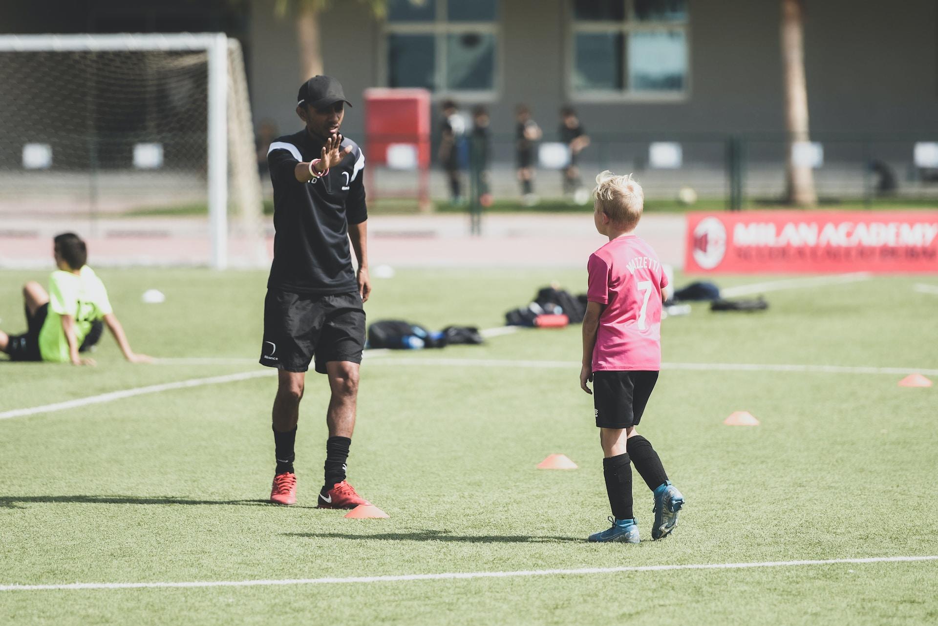 Domare high-fivear ett barn som spelat en match i fotboll.