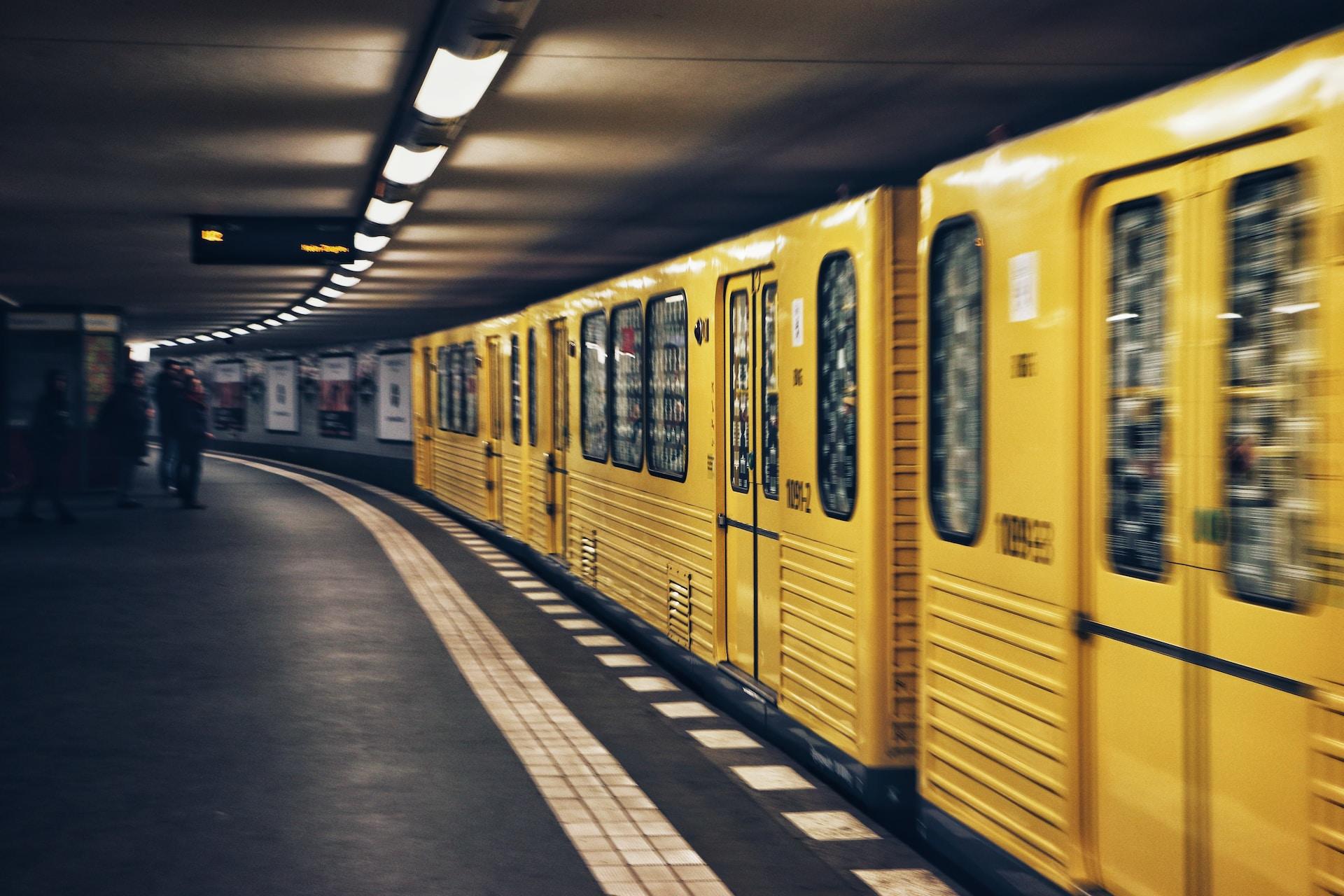 Ett gult tunnelbane-tåg på en hållplats i Berlin.