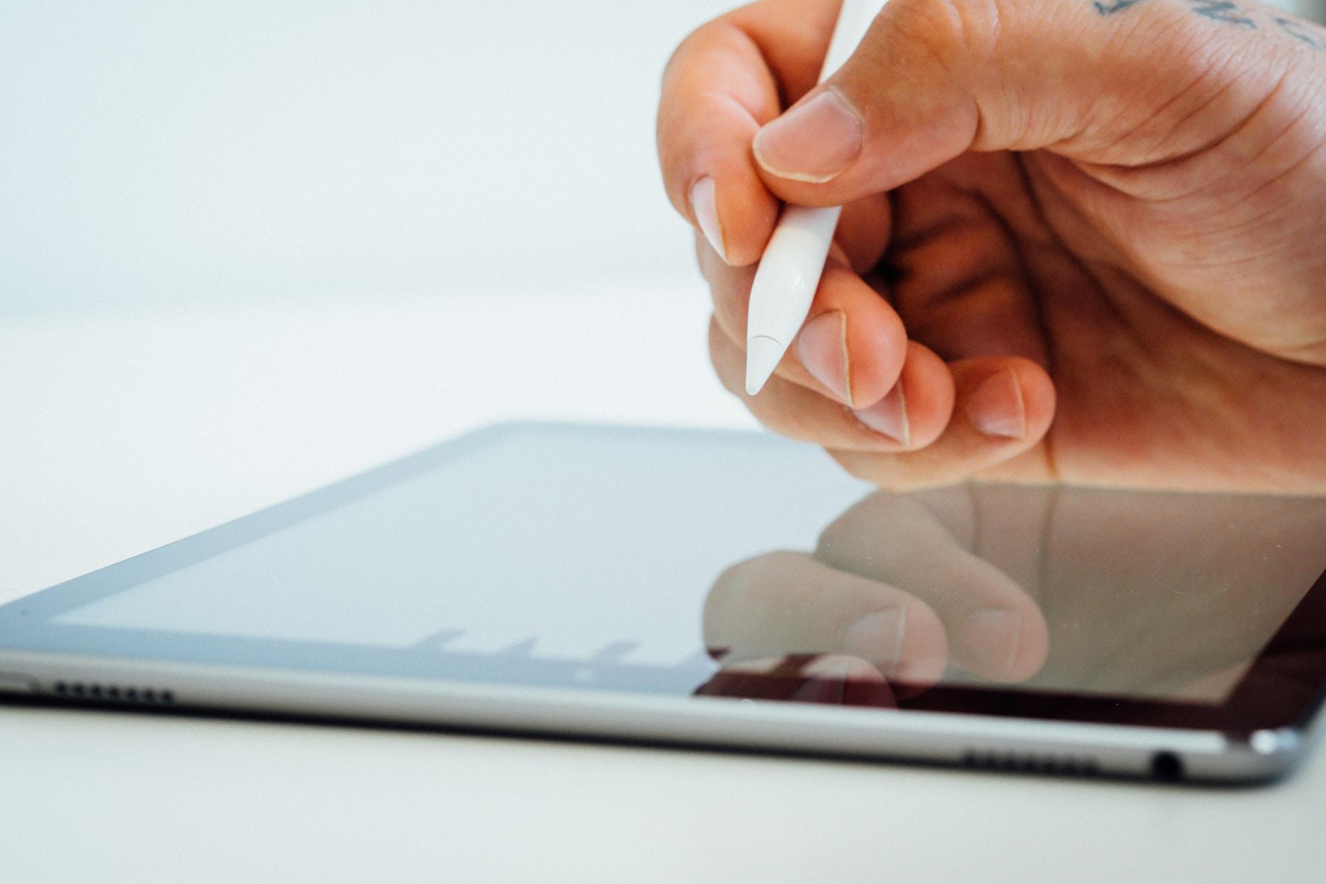 Hand som håller i en "penna" specialtillverkad för iPads.
