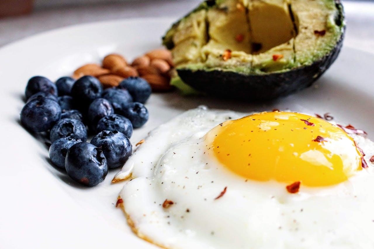 avokado, blåbär, ägg och nötter på en tallrik