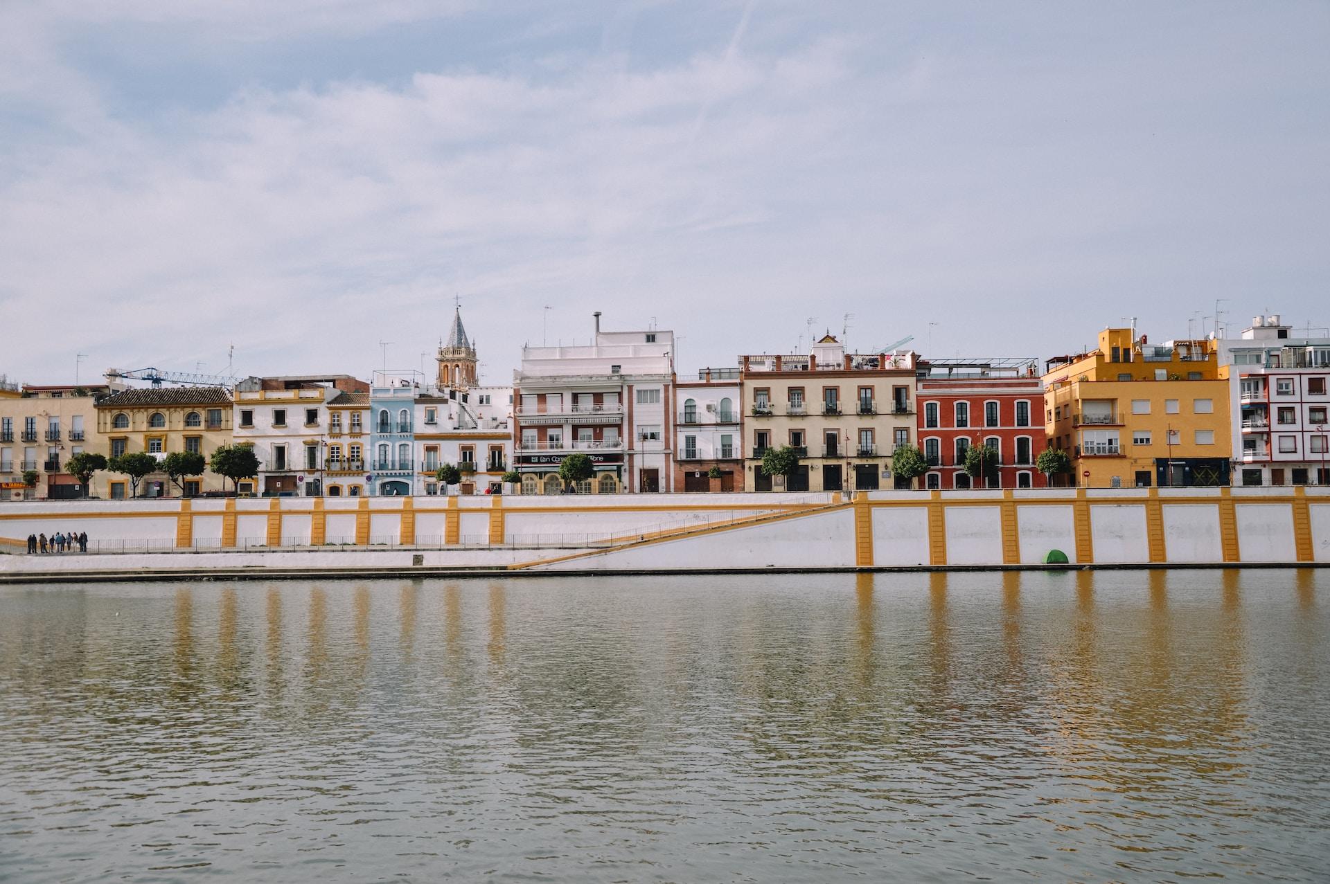 Rad av hus längst med vattnet i staden Sevilla.