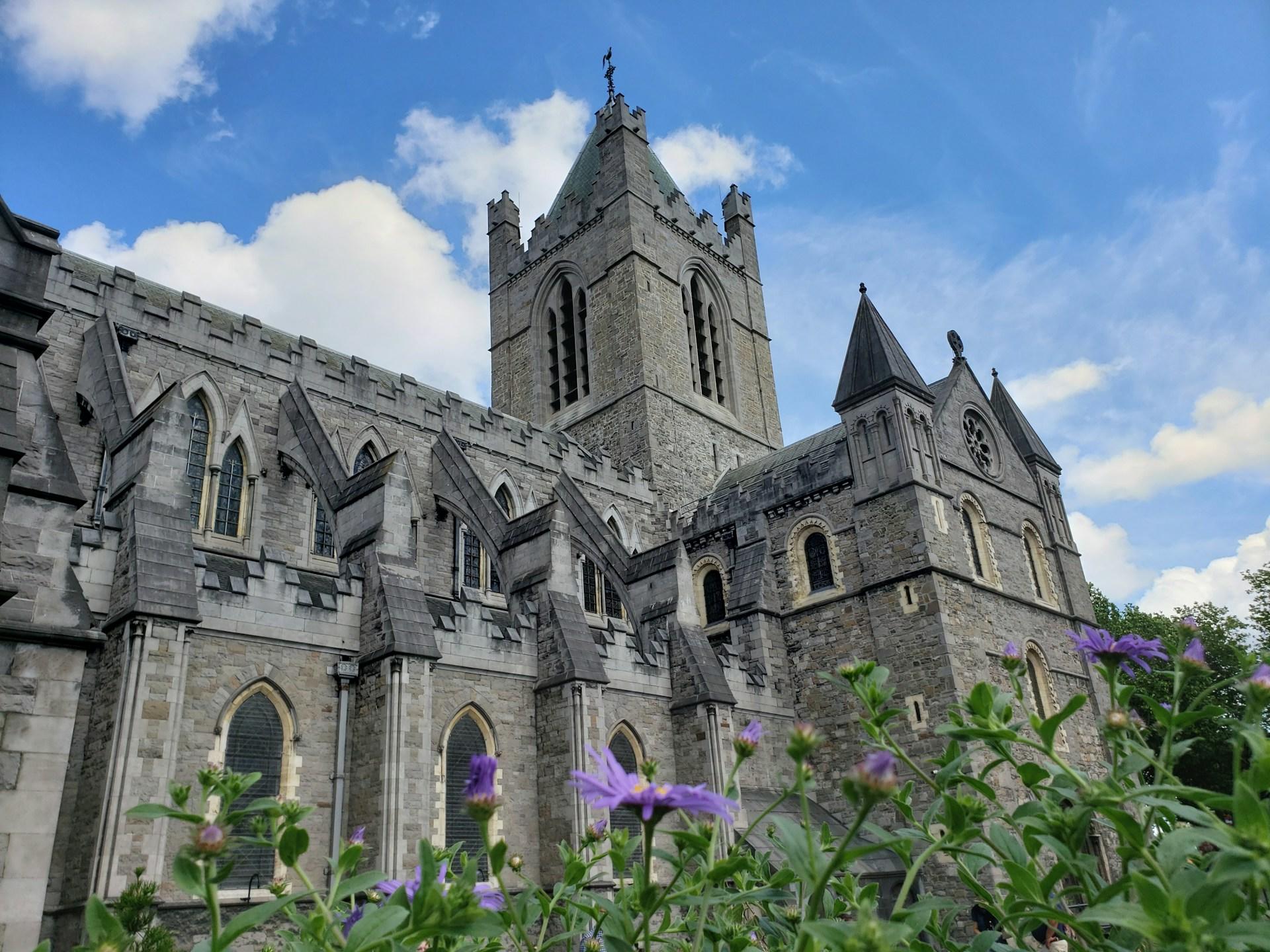 Kyrka i Dublin med blå himmel och lila blommor