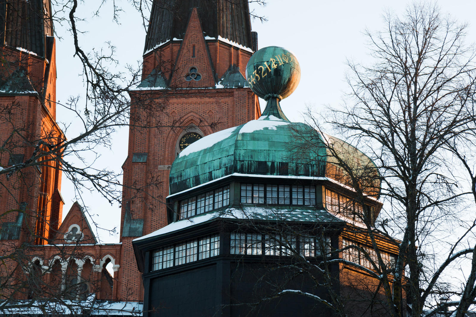 uppsala domkyrka skymtas bakom ett torn som tillhör uppsala universitet