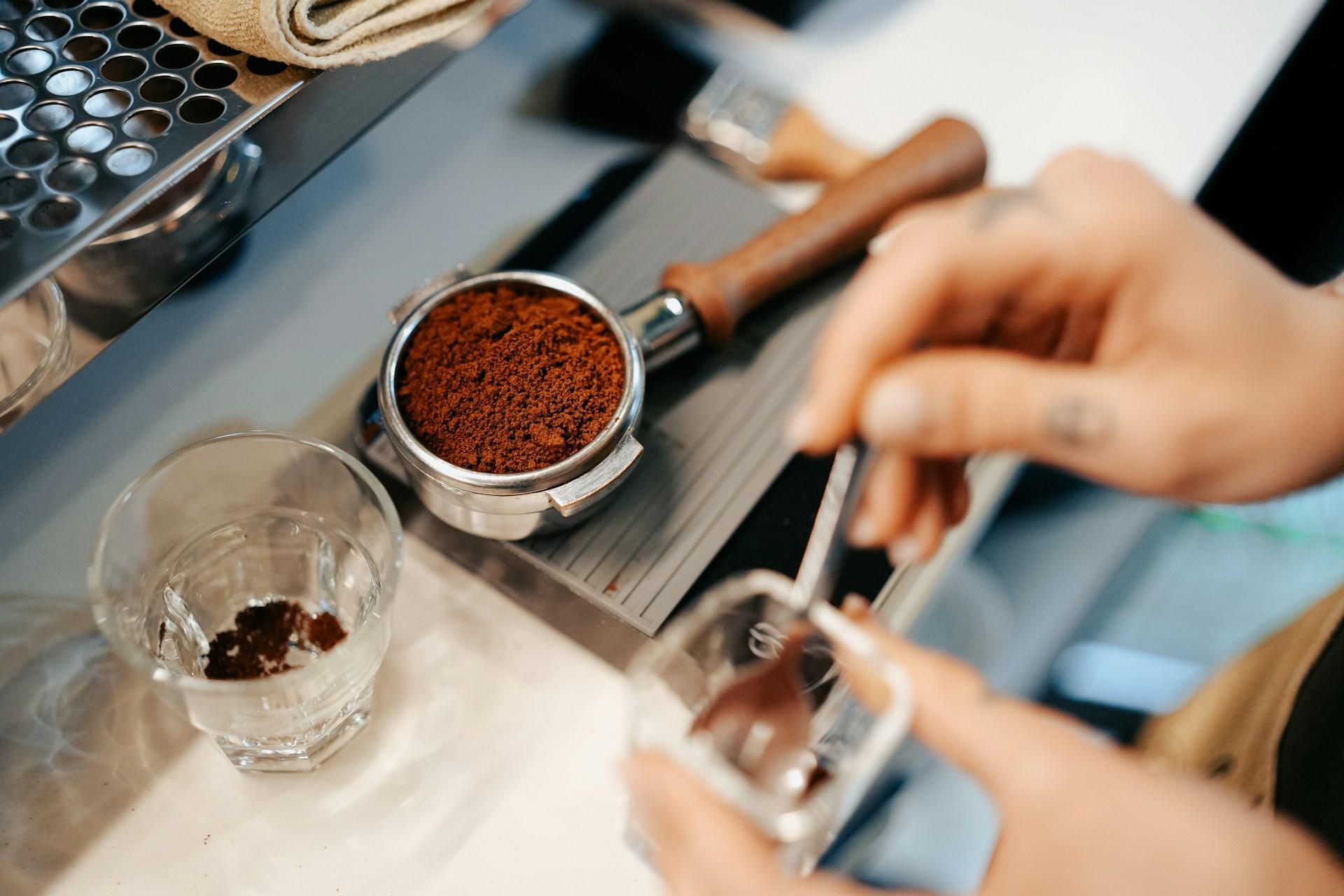 Barista som tillreder kaffe i en espressomaskin.