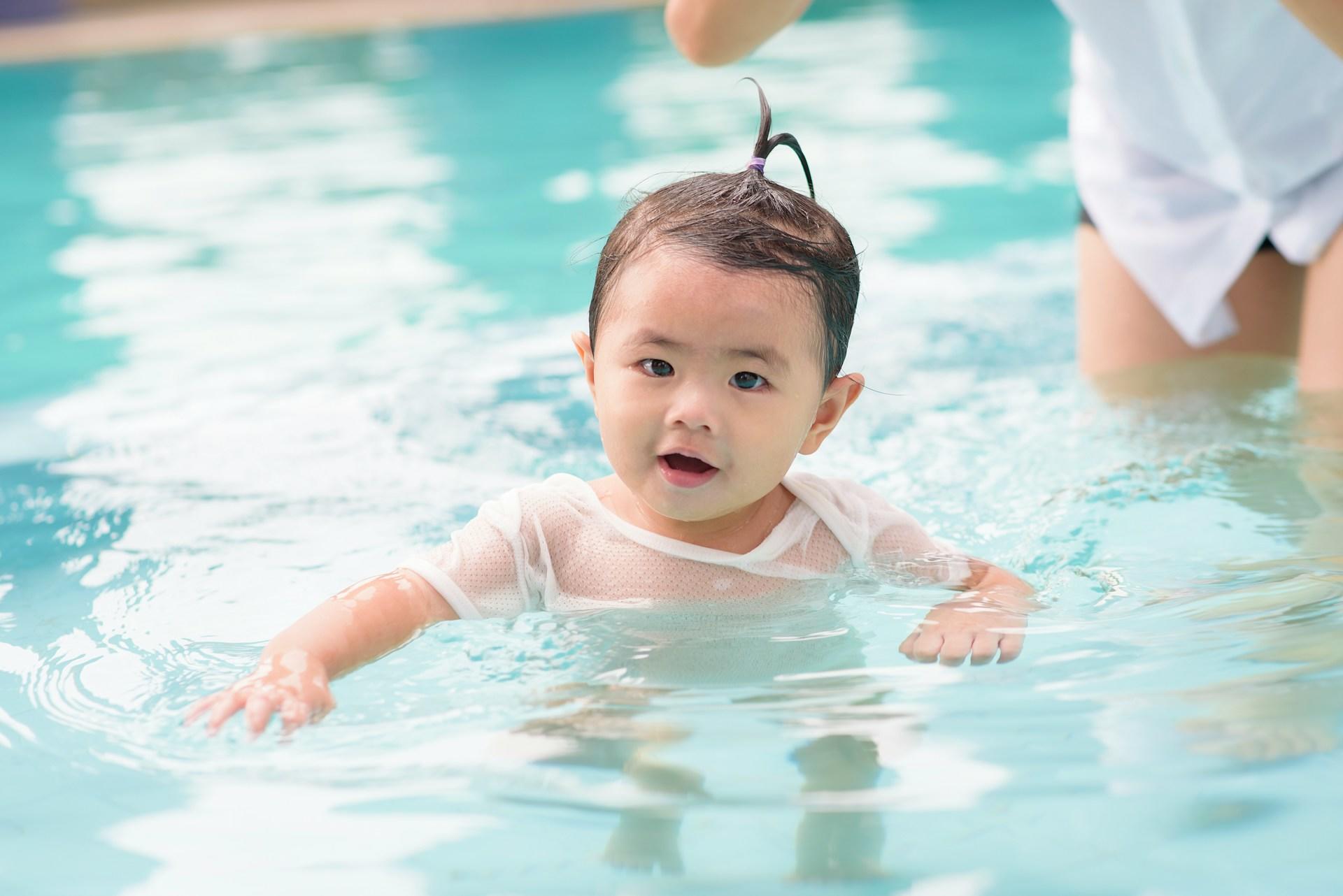 bebis i vitt linne i en pool