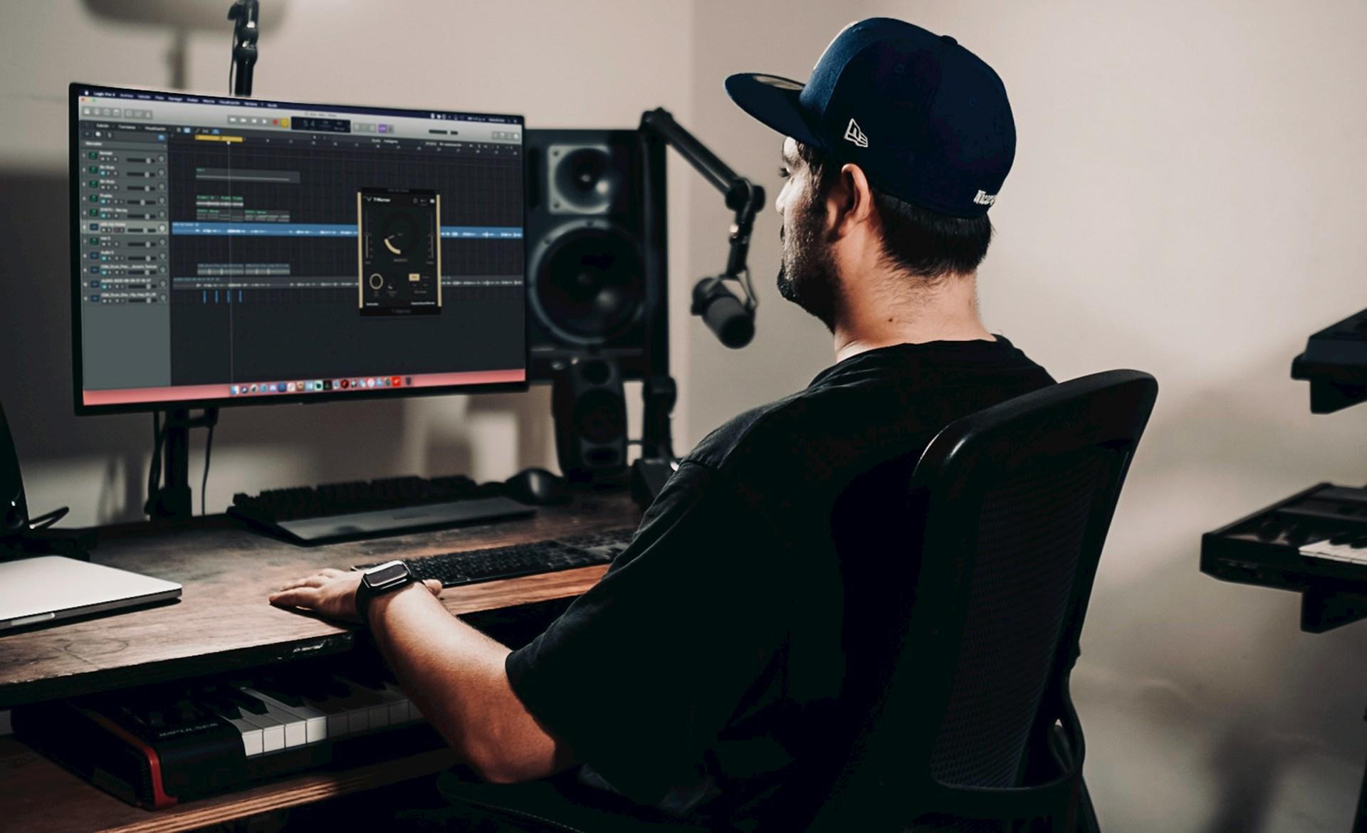 Man i keps som gör musik i studio